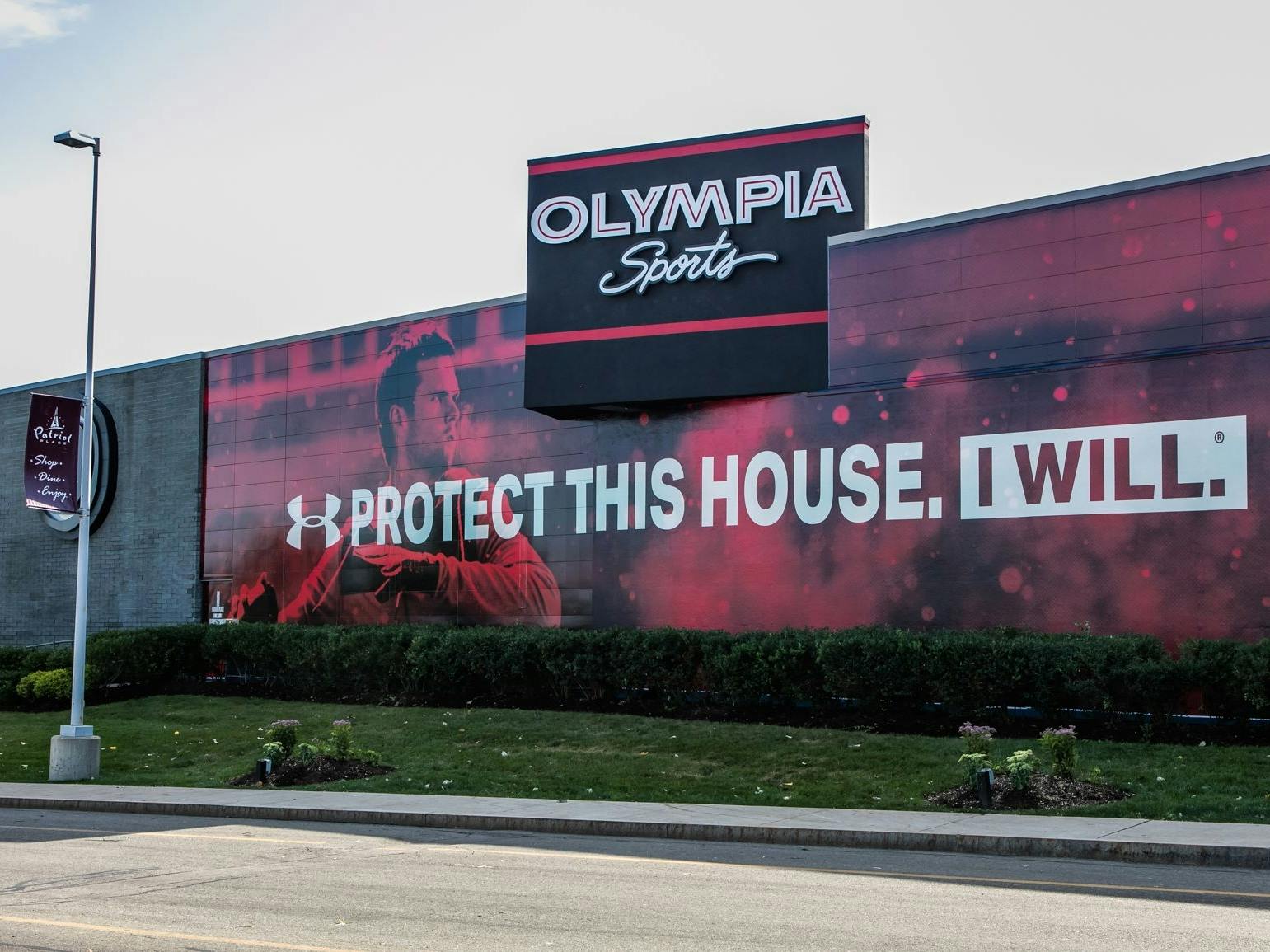 Olympia Sports store with an under armour slogan displayed on the side of the building. "Protect this house. I will.
