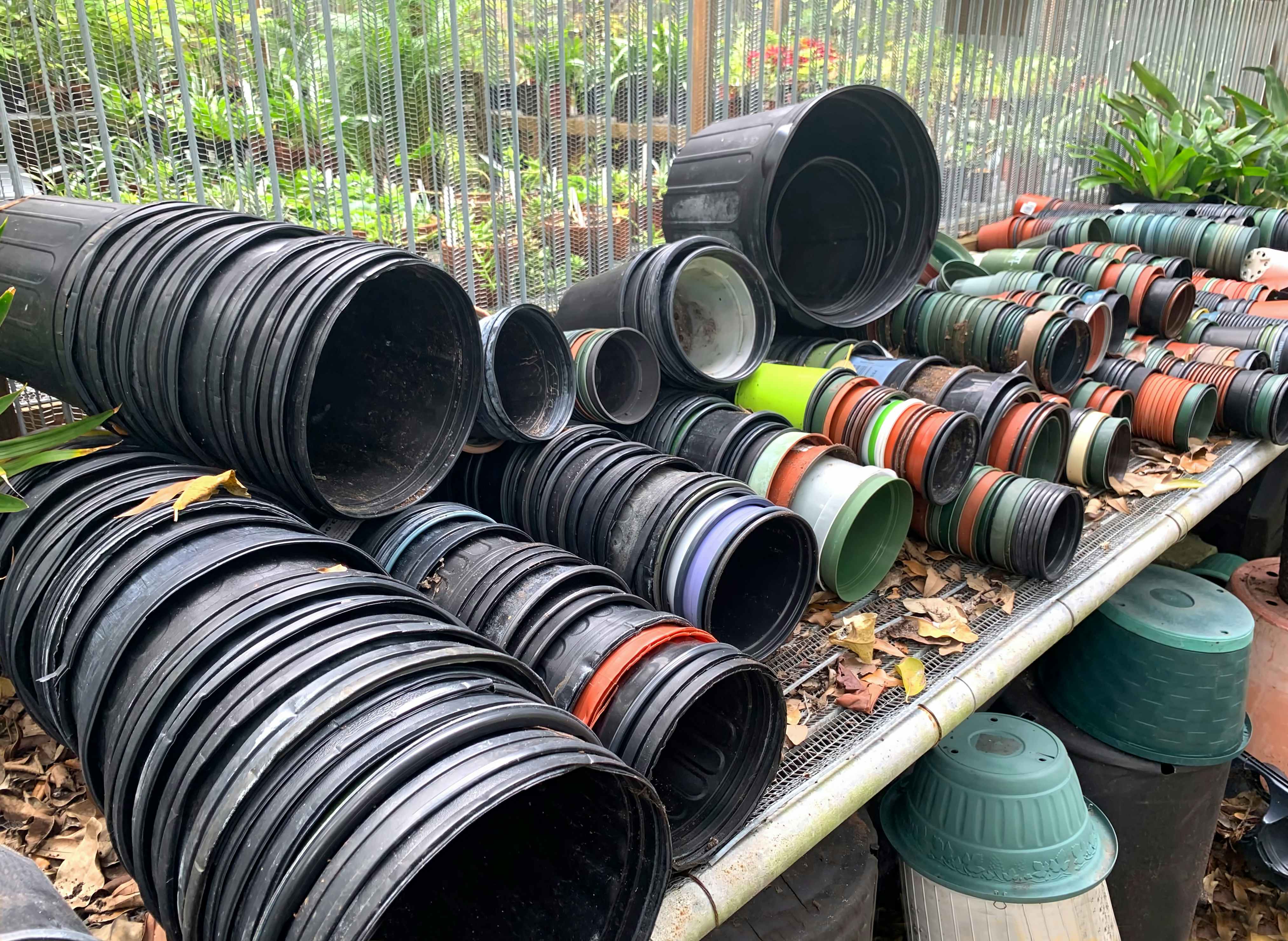 Used plastic garden pots in an outdoor garden center or store.