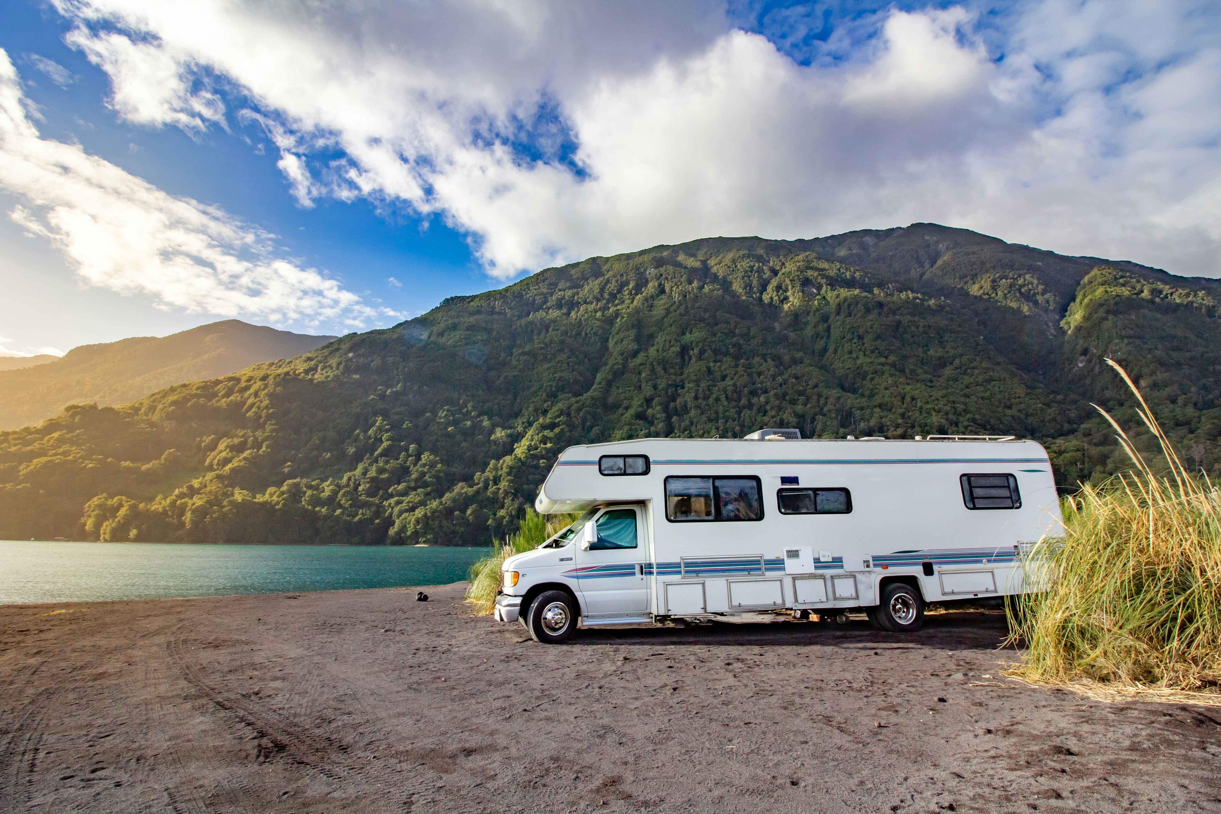 An RV parked by a lake.