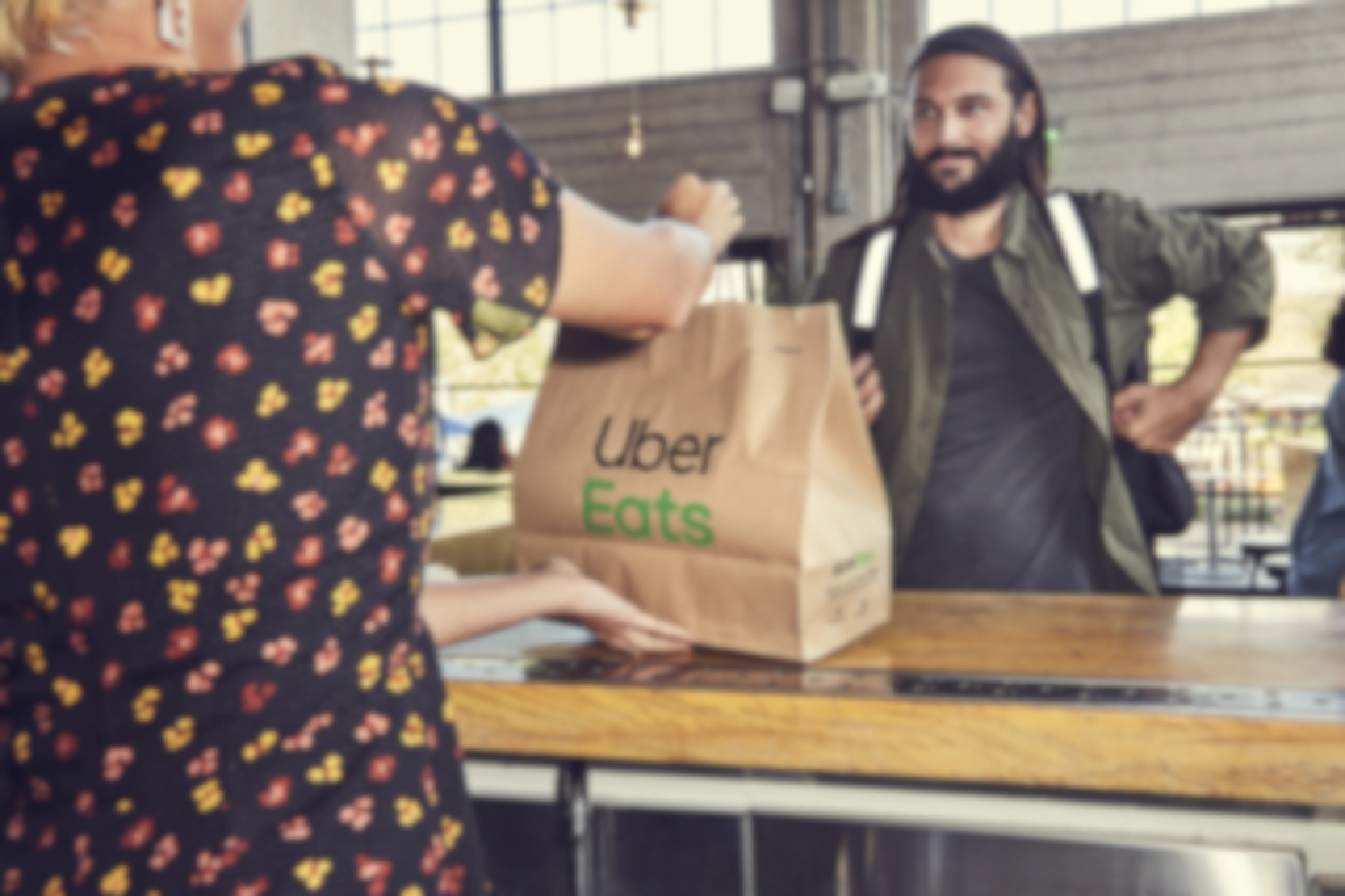 an Uber Eats delivery person picking up an order from a restaurant