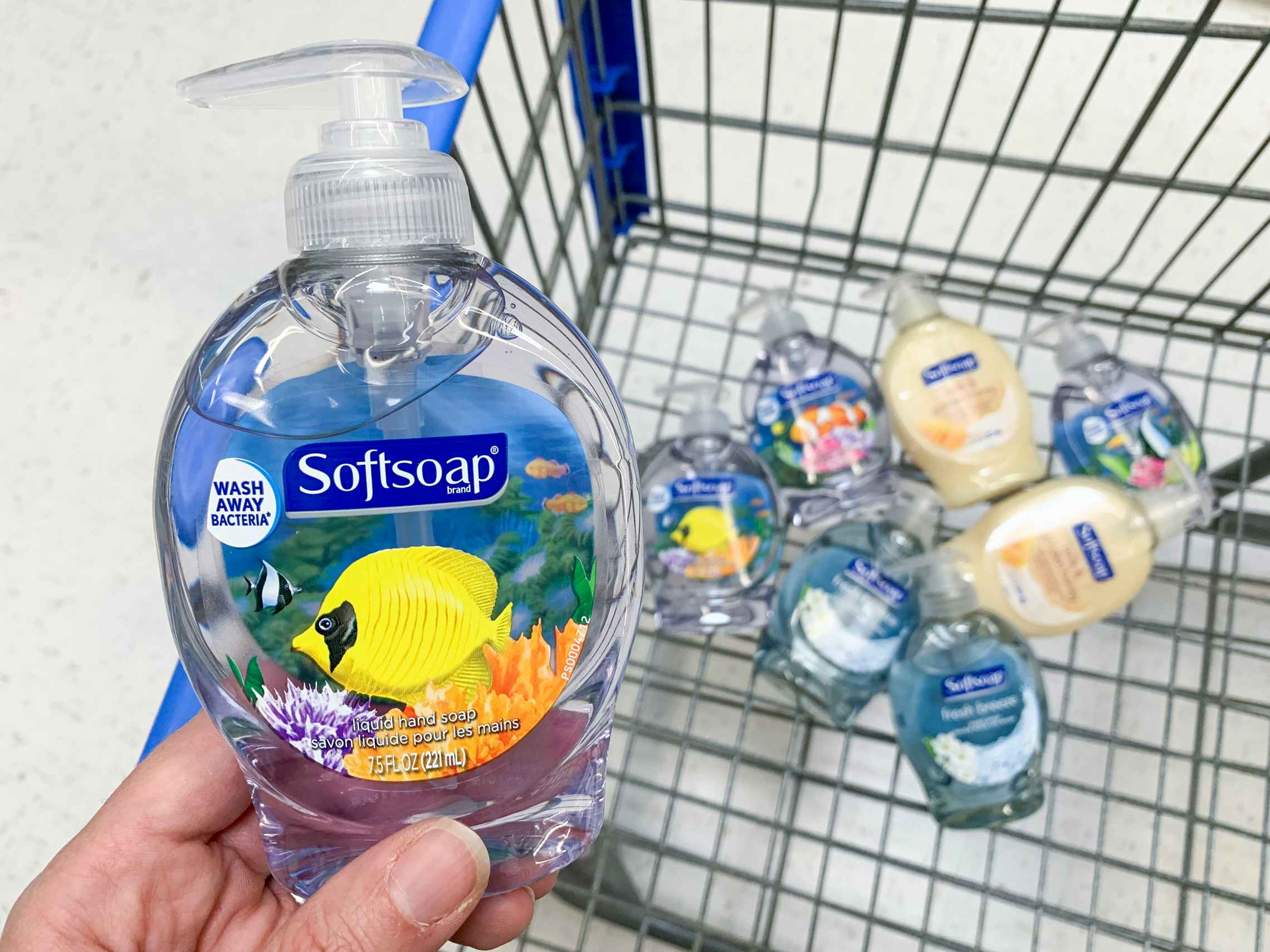 Hand soap held in over a shopping cart filled with the same products. 