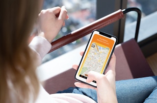 woman holds phone with mobee app on it