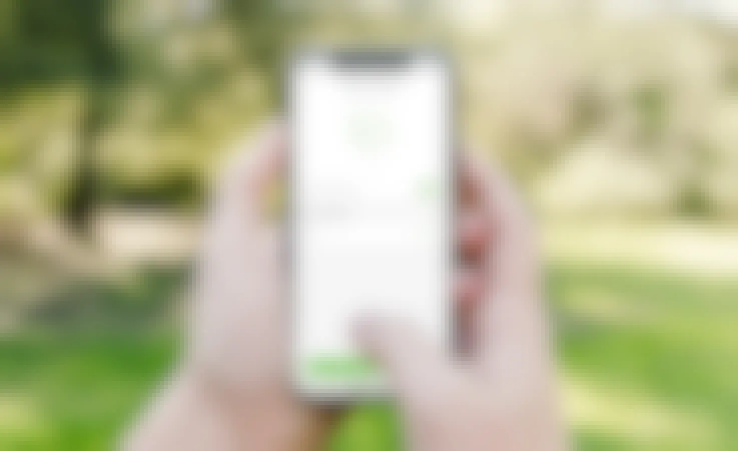 A person holding a cell phone with the acorns app on it.