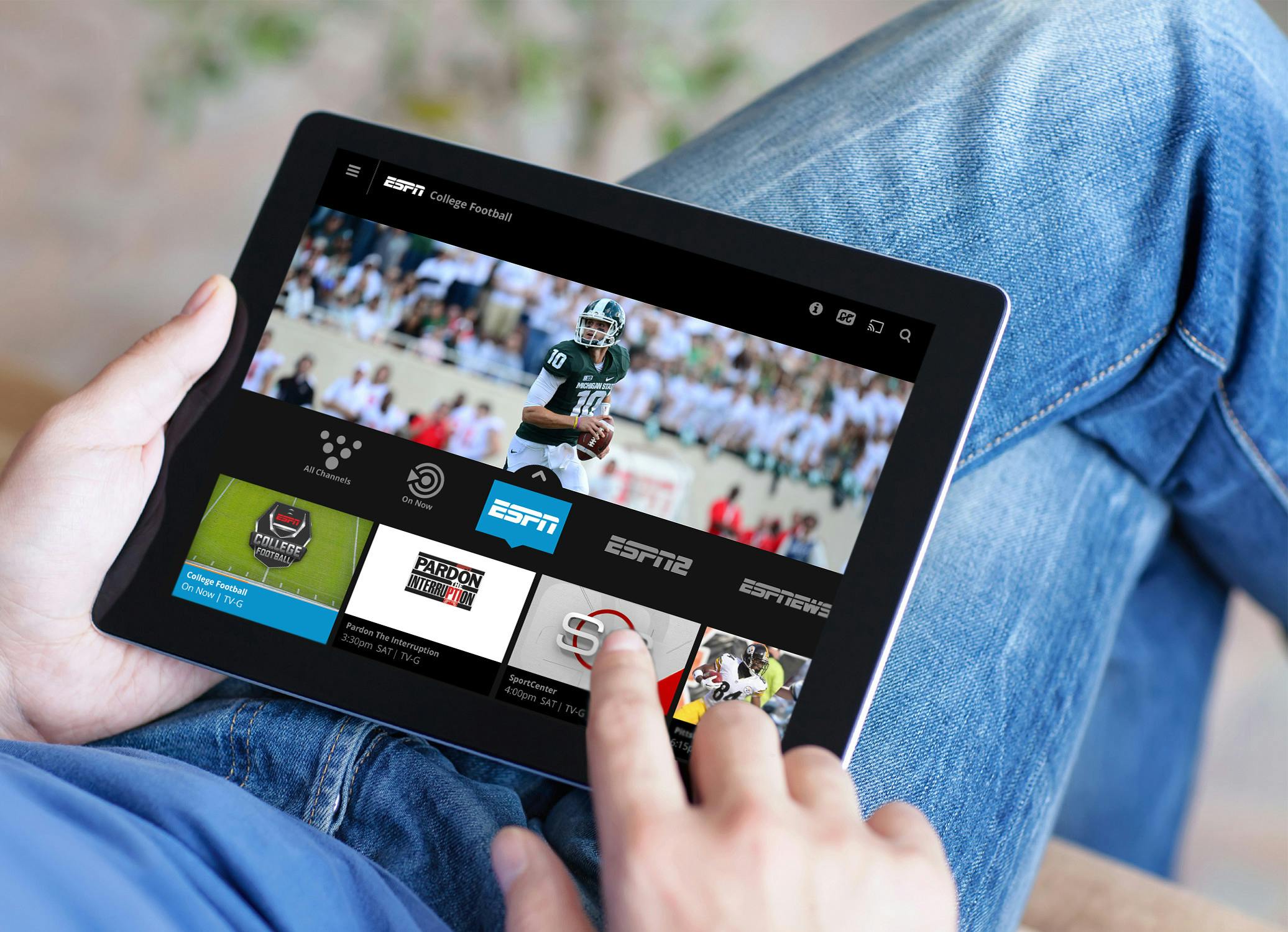 person holding tablet watching sports with Sling app