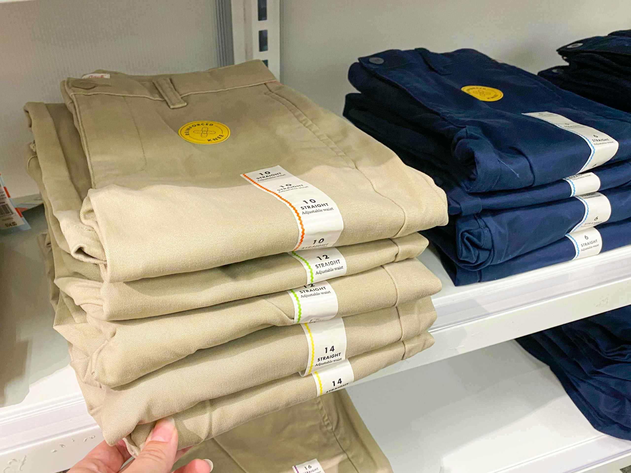 Stacks of Cat & Jack school uniform slacks on a shelf at Target.