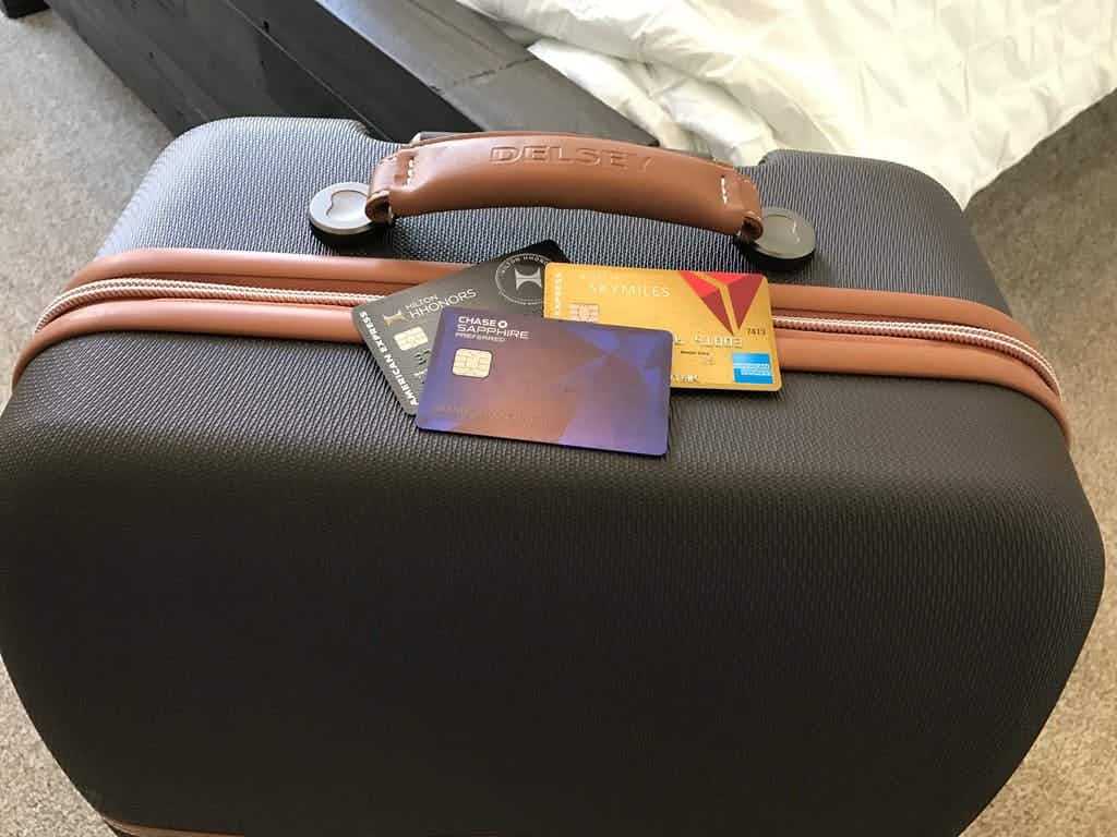 Travel credit cards sitting on top of a suitcase.