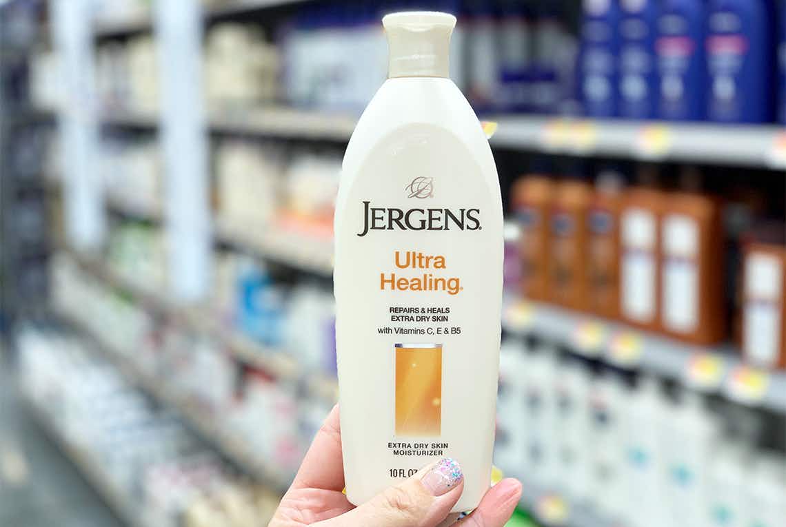 Hand hold a tan Jergens lotion bottle