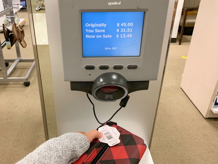 A person scanning a product to reveal a sales price.