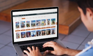 young boy looks at gamefly website on his laptop