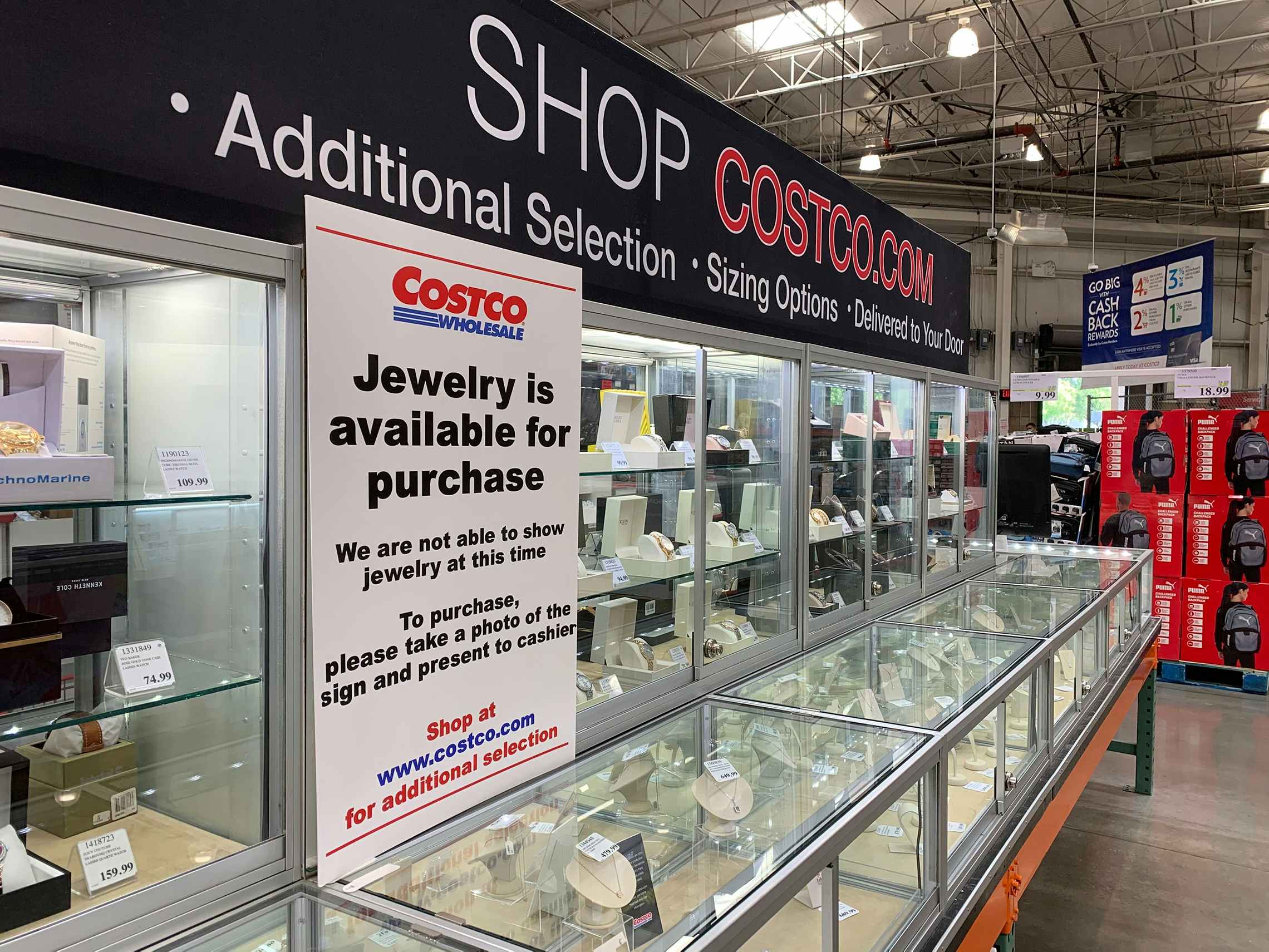 costco jewelry section with shop costco.com sign and covid sign