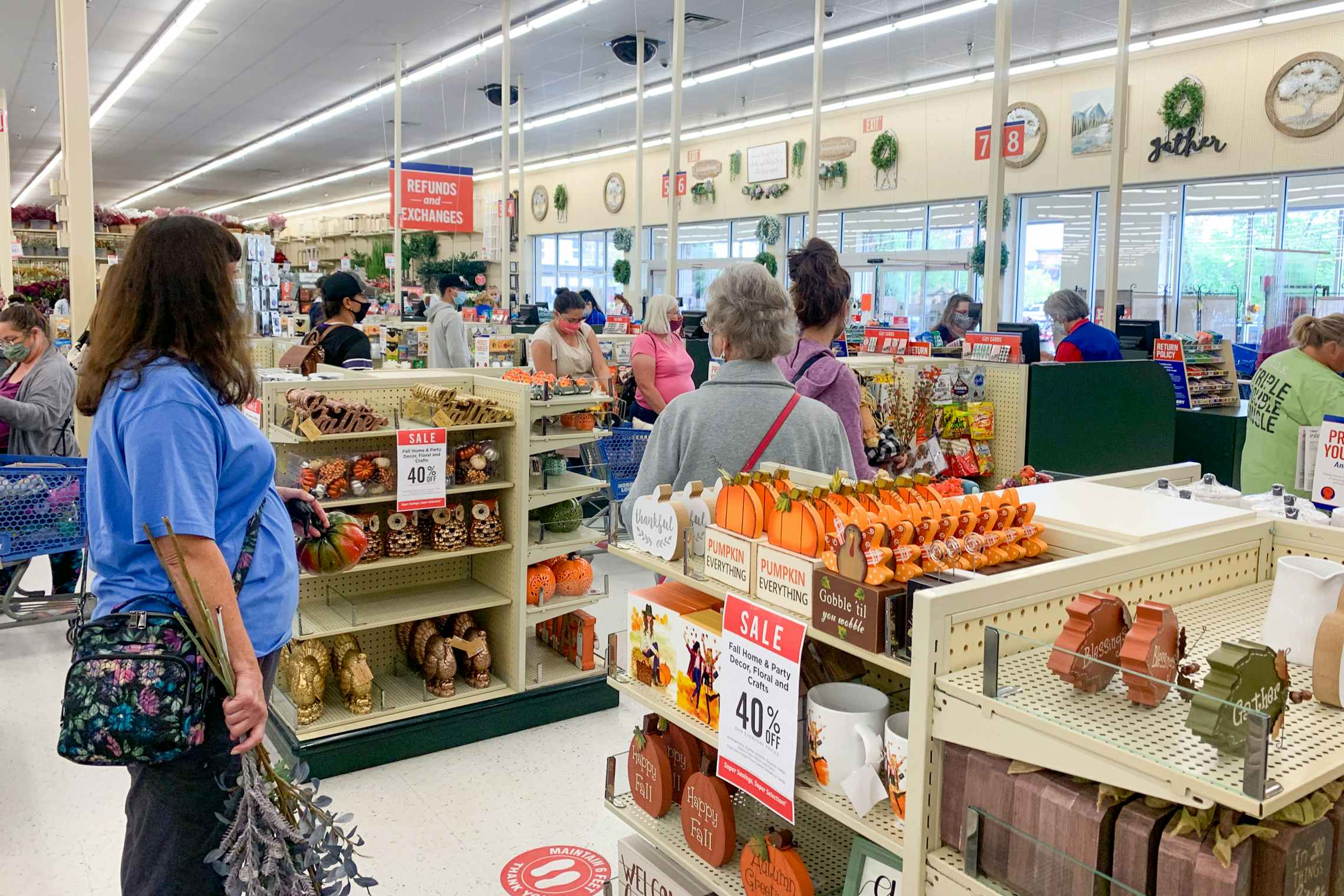 Customers wearing face masks, waiting in line at checkout, inside Hobby Lobby.