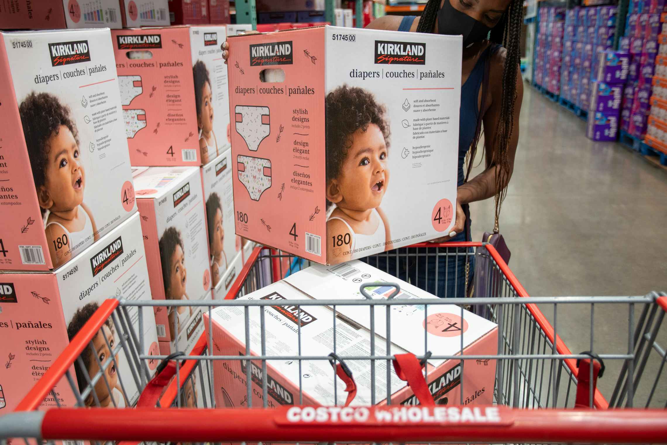 A woman shopping for Kirkland diapers inside Costco.