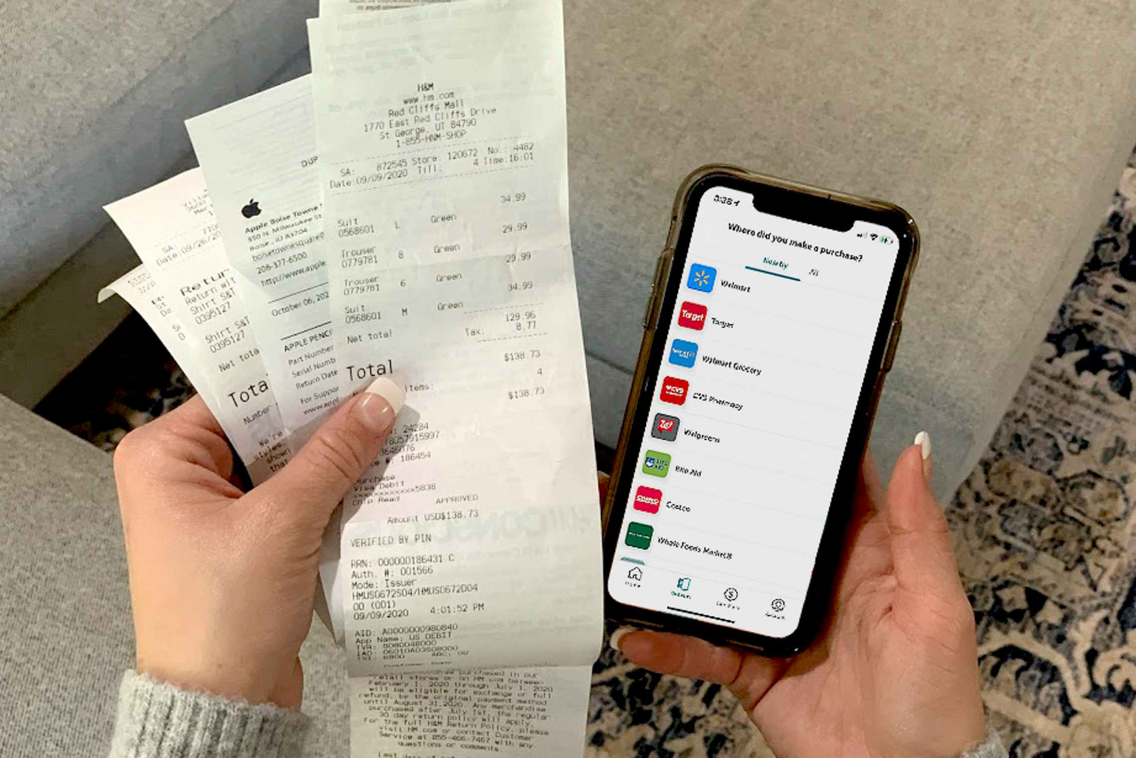 Someone using their iphone with ibotta to save and get cash back with paper receipts