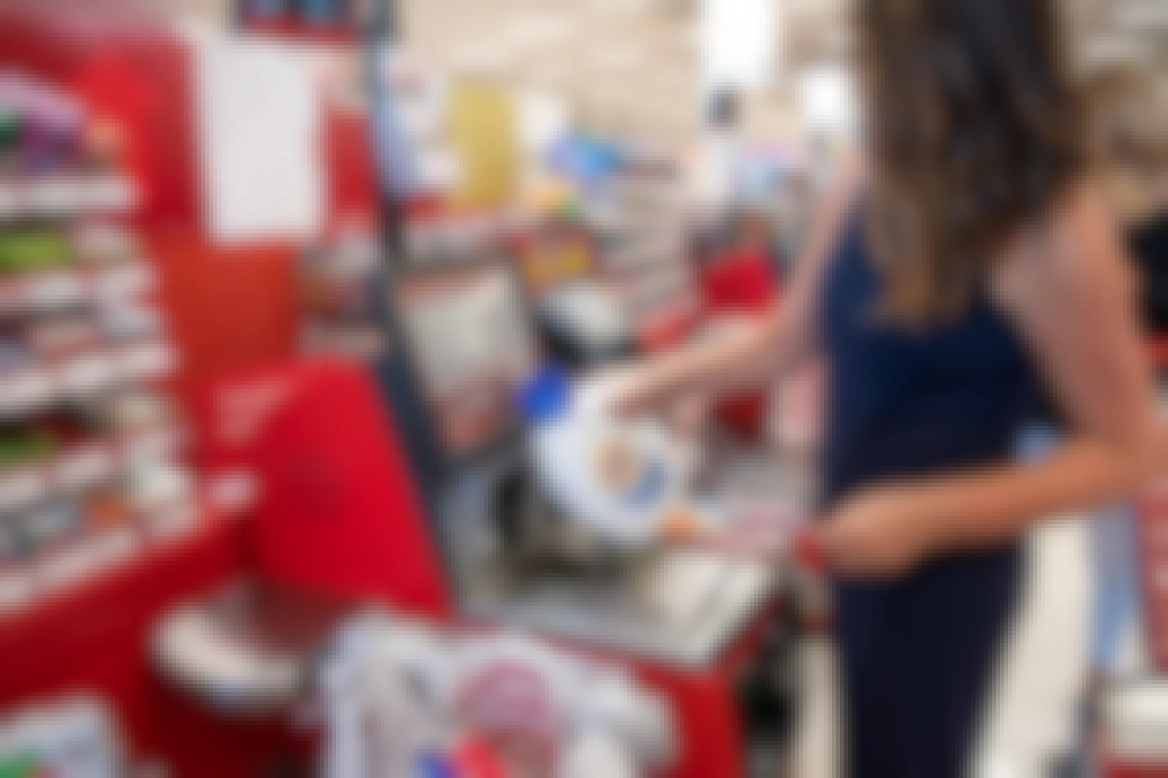 A woman scanning a bottle of laundry detergent at the Target self-checkout kiosk.