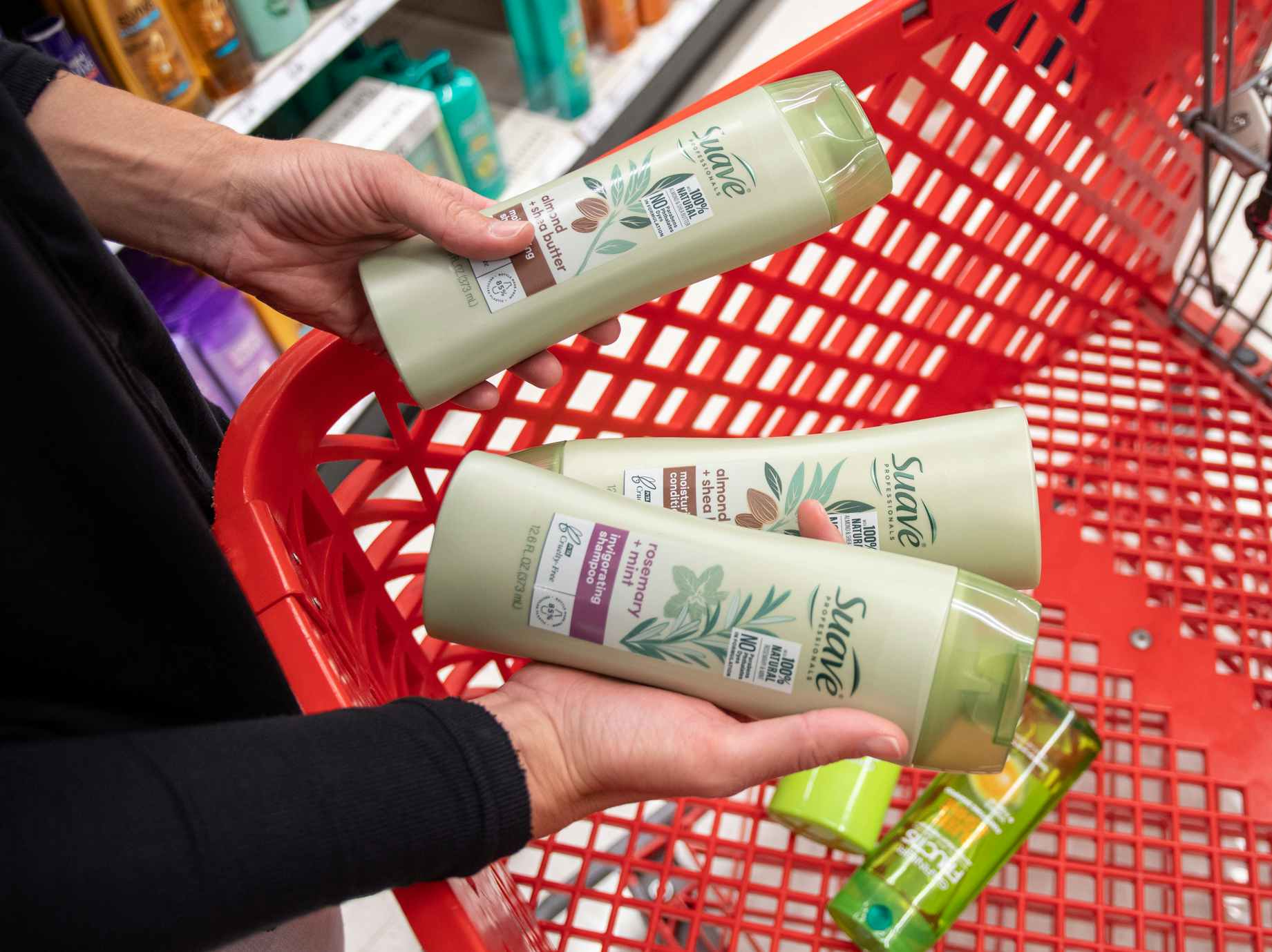 A person putting some Suave haircare products into a Target shopping cart