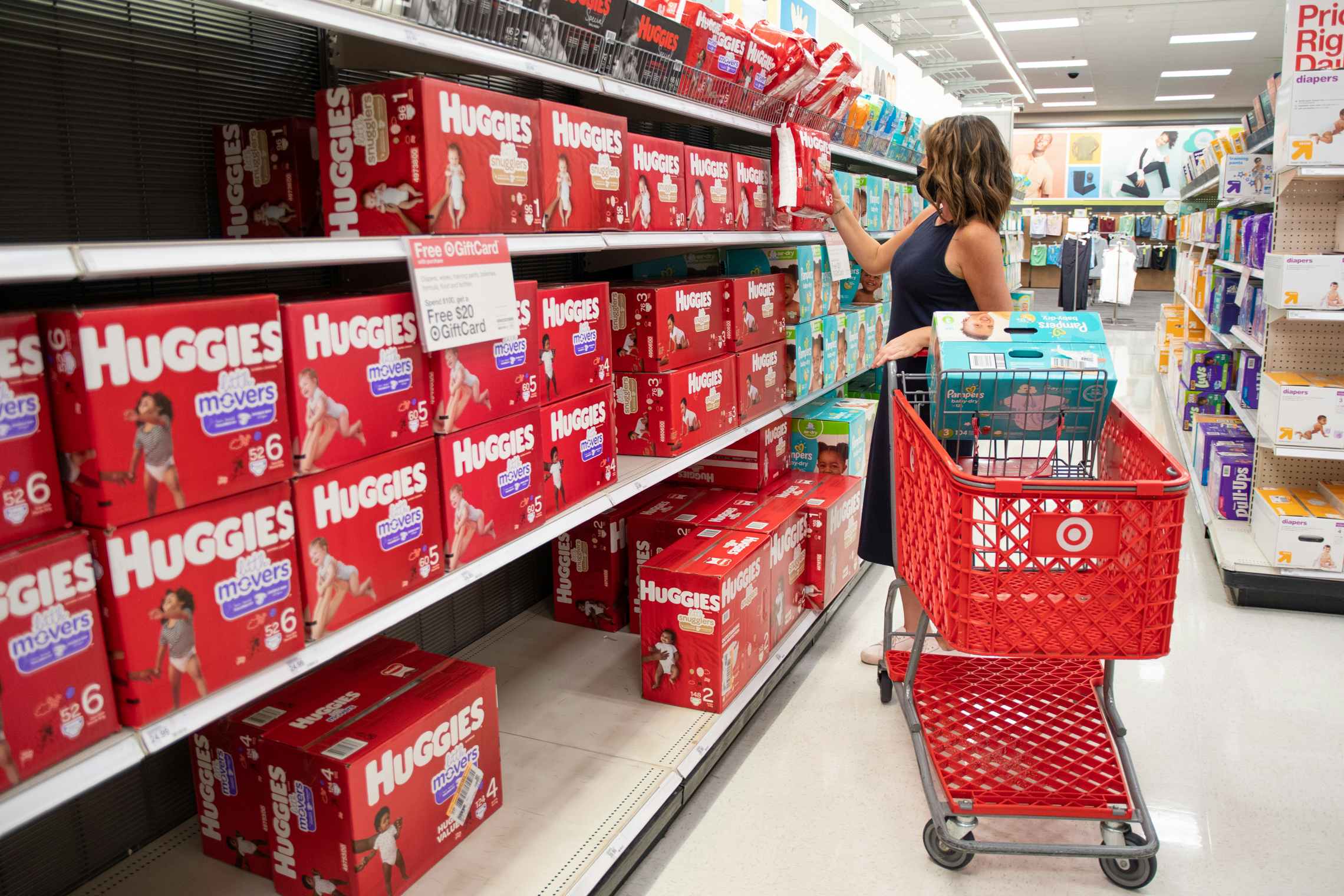 A woman shopping for Huggies diapers inside Target.
