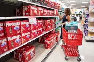 A woman shopping for Huggies diapers inside Target.