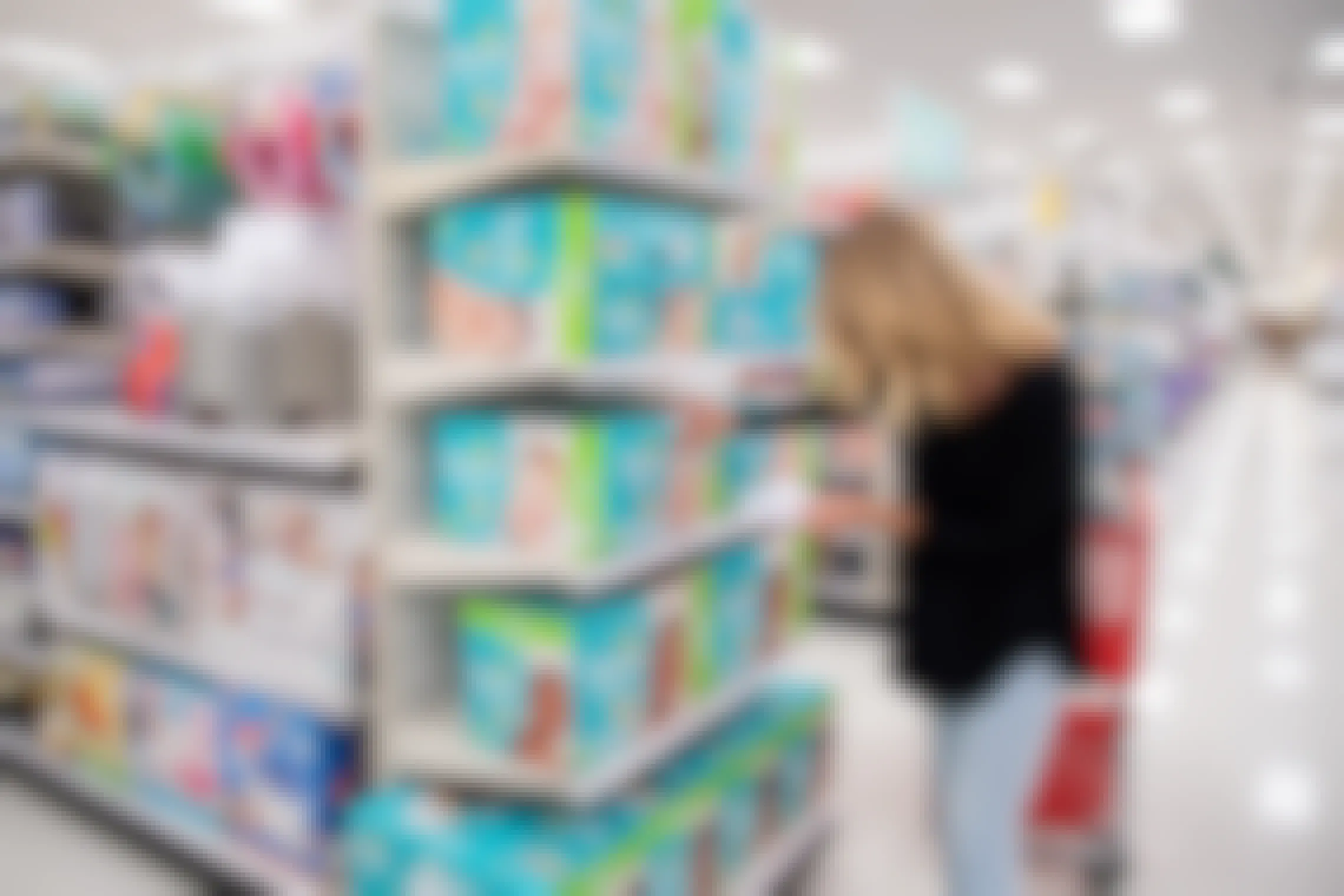 A woman shopping for Pampers diapers with coupons in Target.