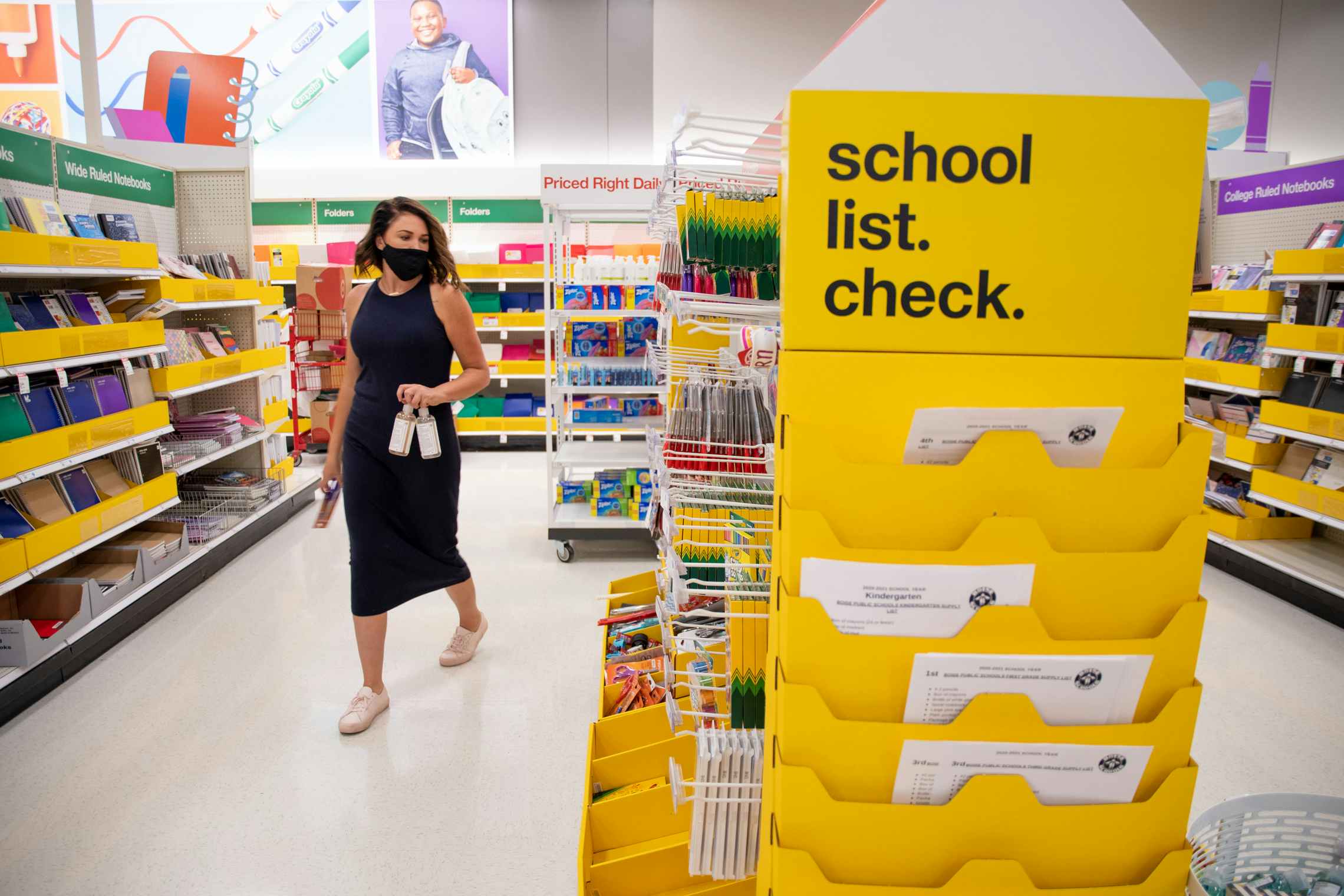 A woman shopping for school supplies at Target near a sign that says "School list. Check.