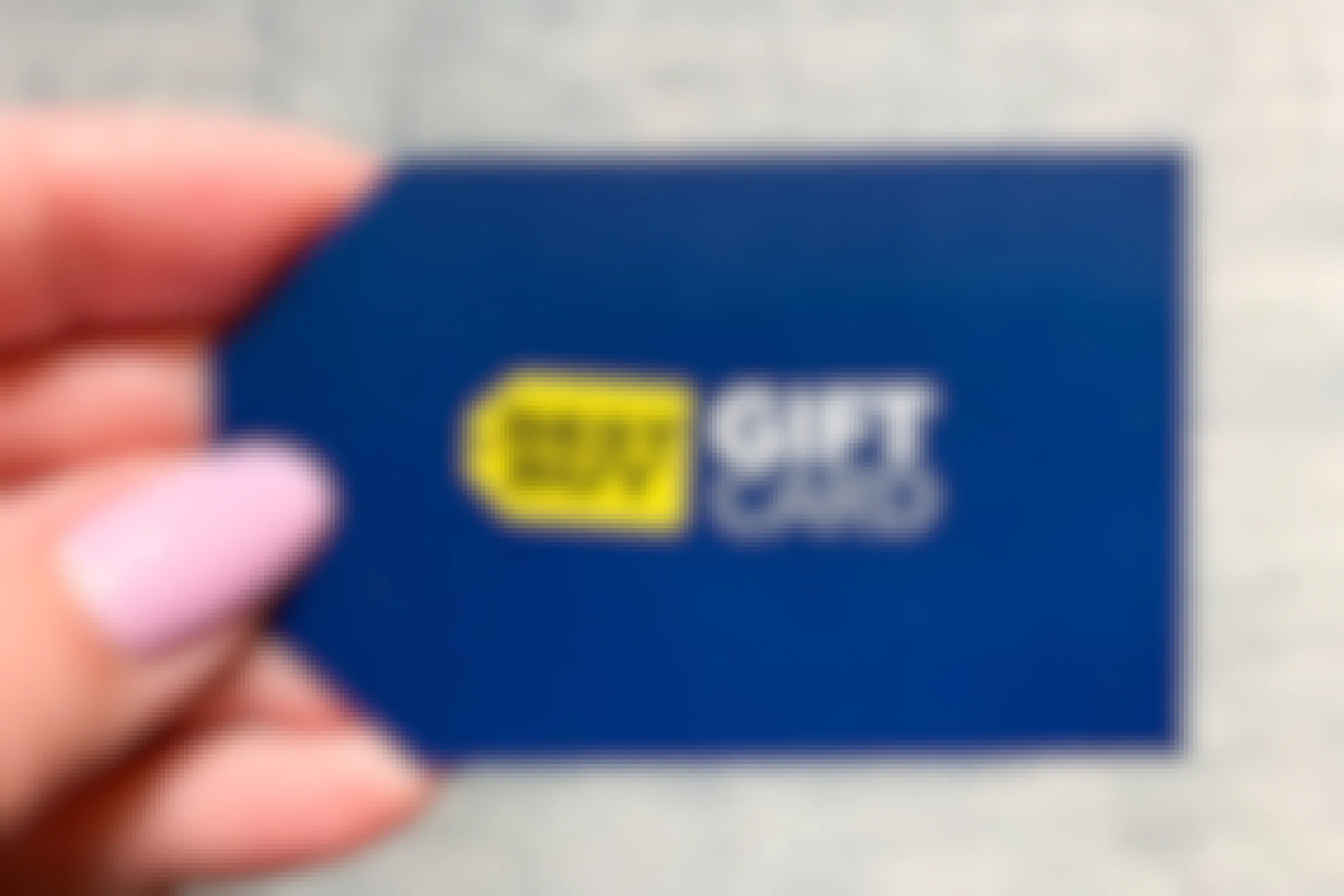 A person holding a Best Buy gift card.