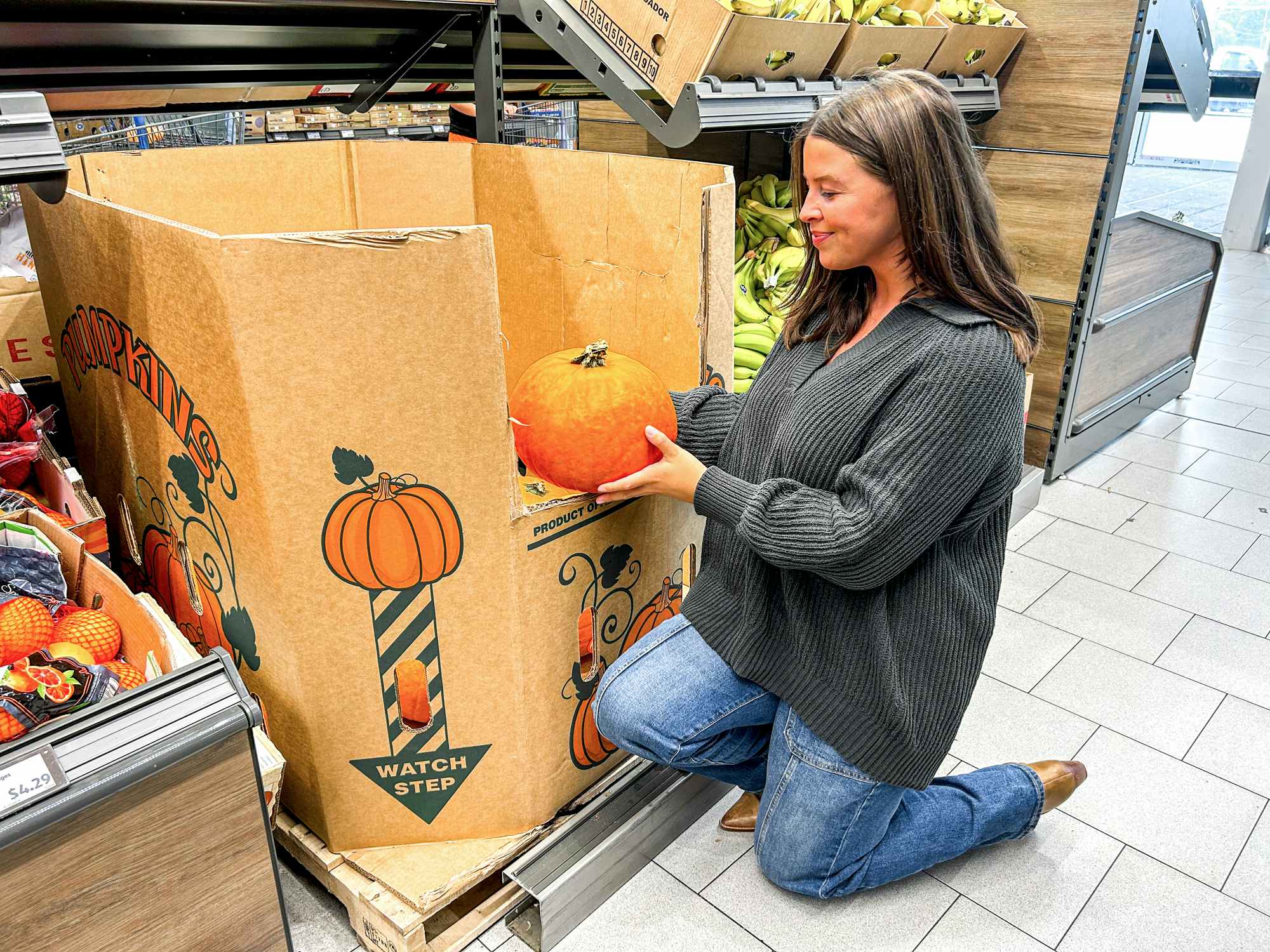 a person holding up a pumpkin at aldi