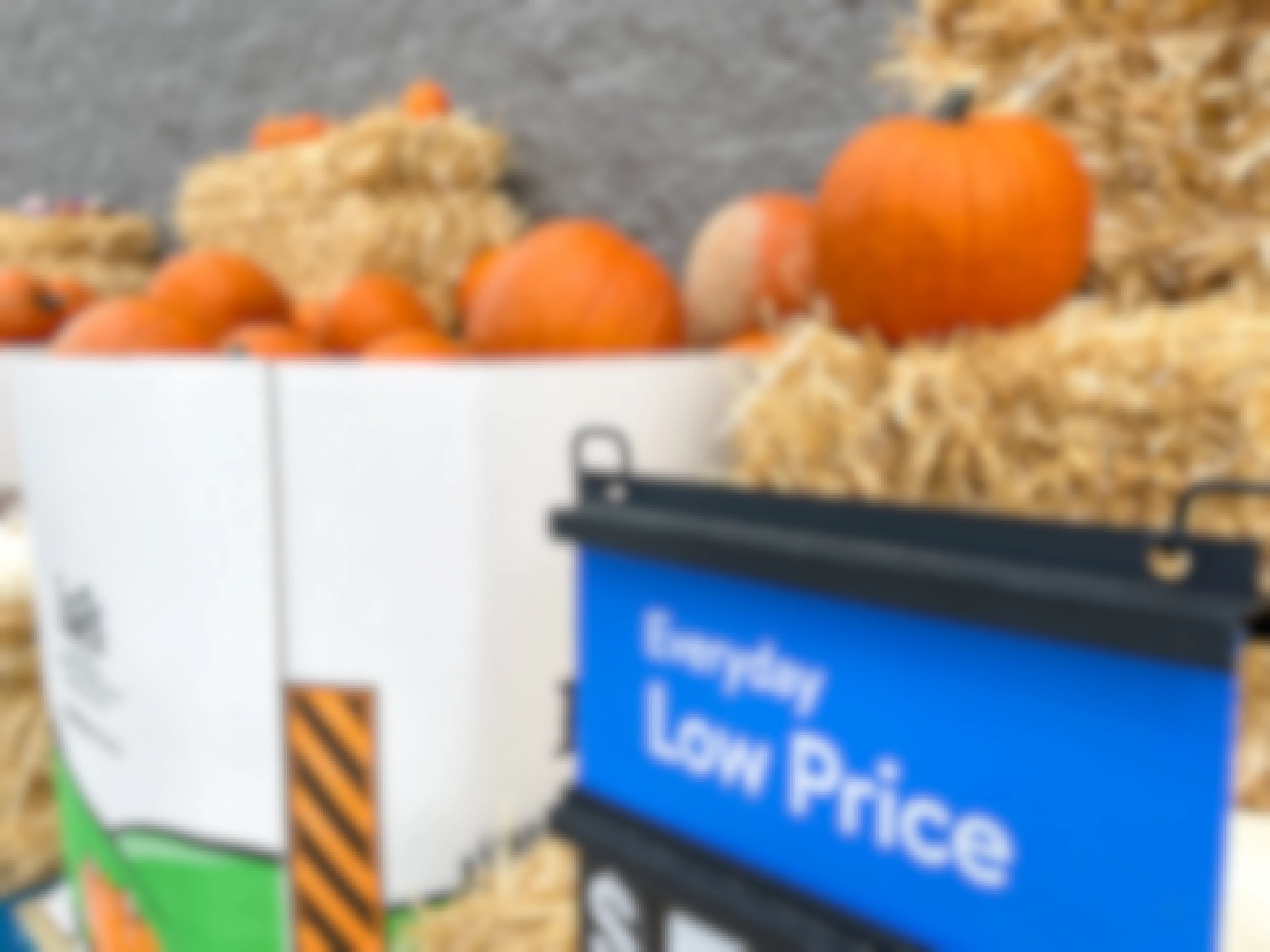 Large boxes filled with pumpkins along the outer wall of a Walmart with a sign that reads, "Everyday Low Price