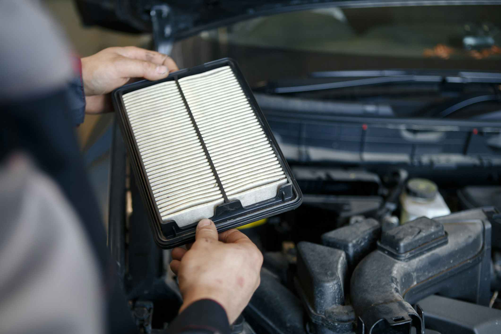 Hand of a man changes and check air filter of car in the engine