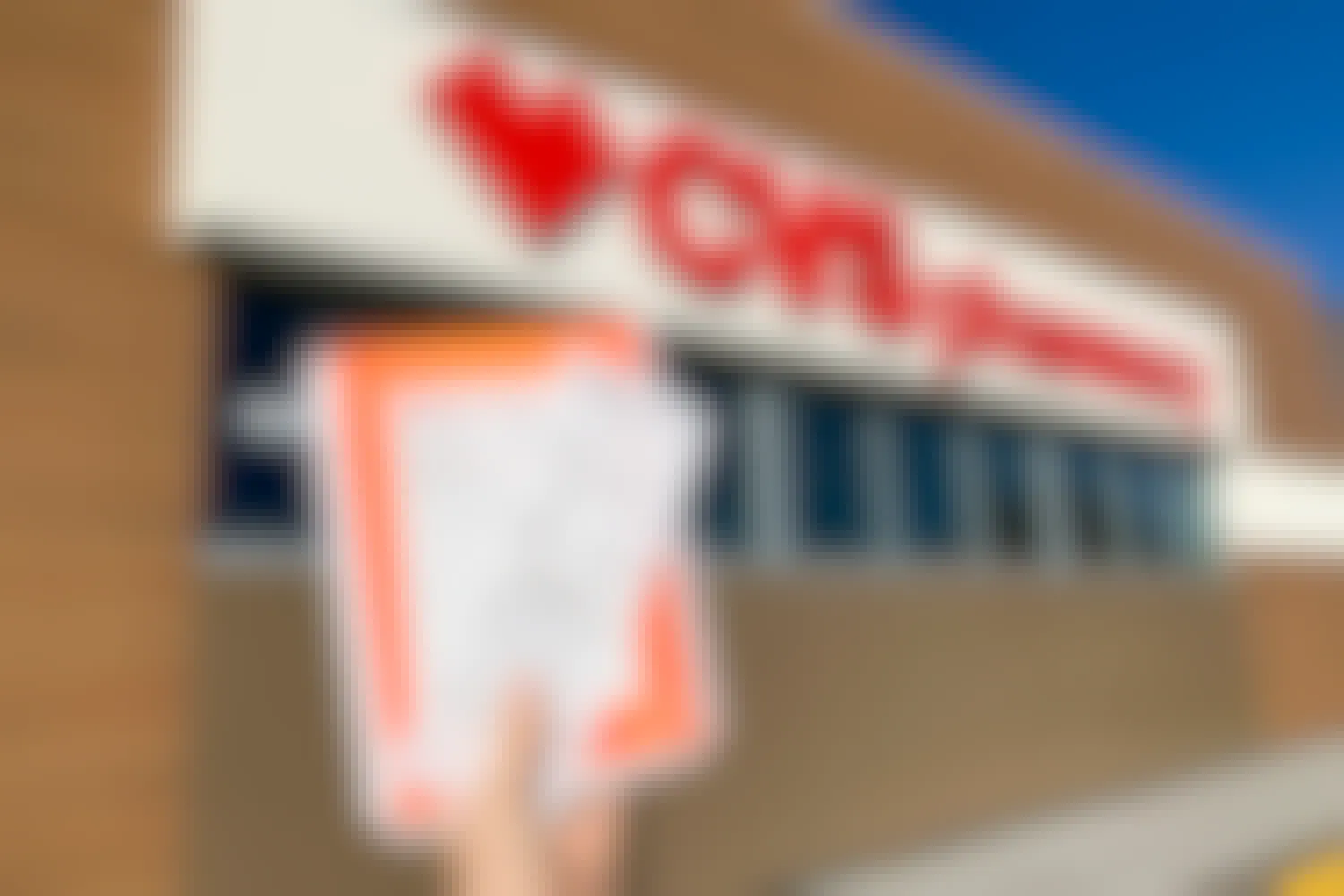 woman holding up cvs photo prints in front of store