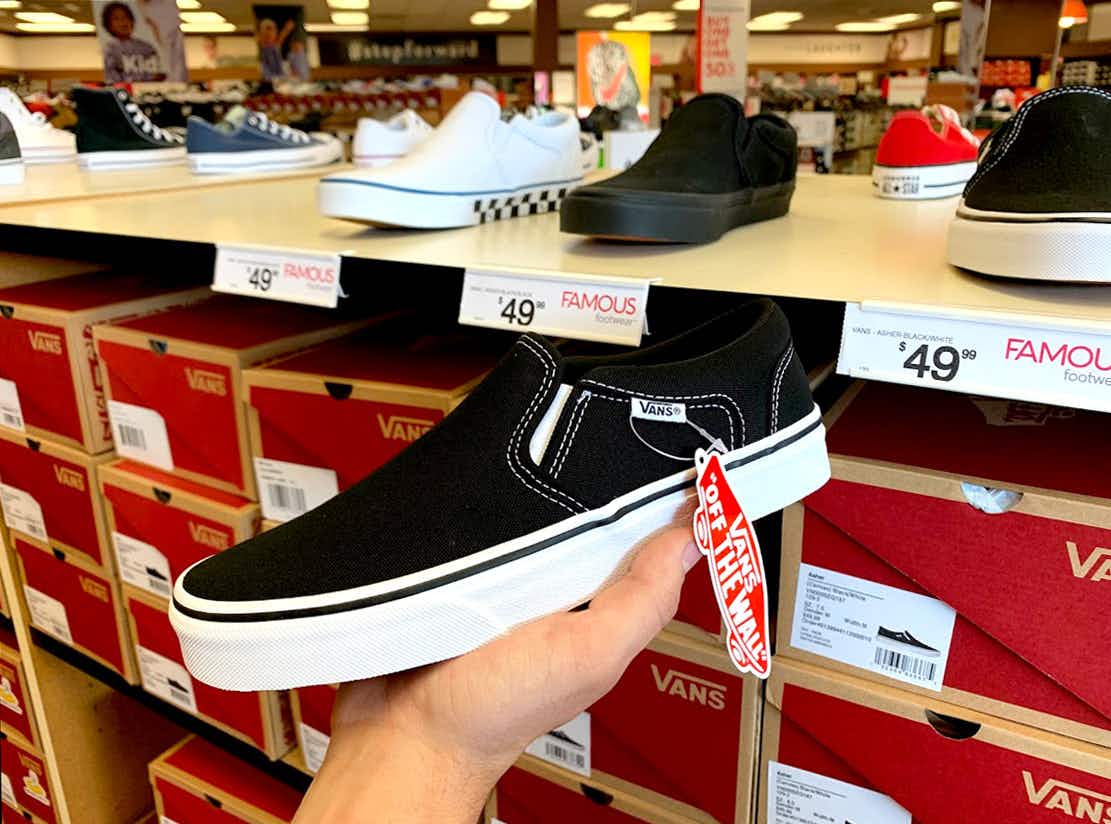 Someone holding up Vans slip on shoe in famous footwear