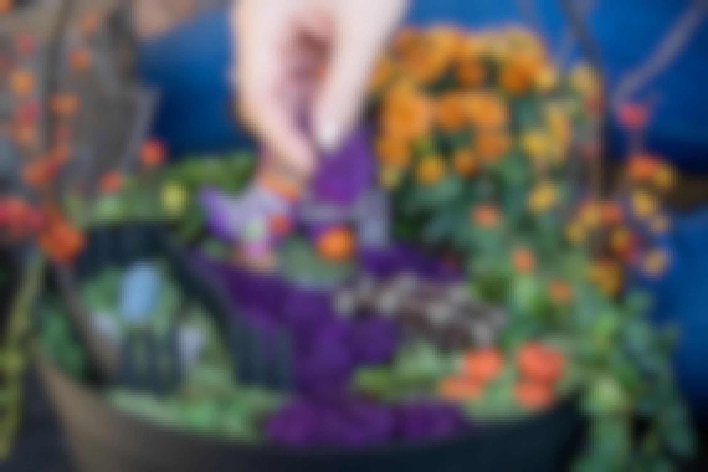 Purple moss being placed in a Halloween-themed Fairy Garden.