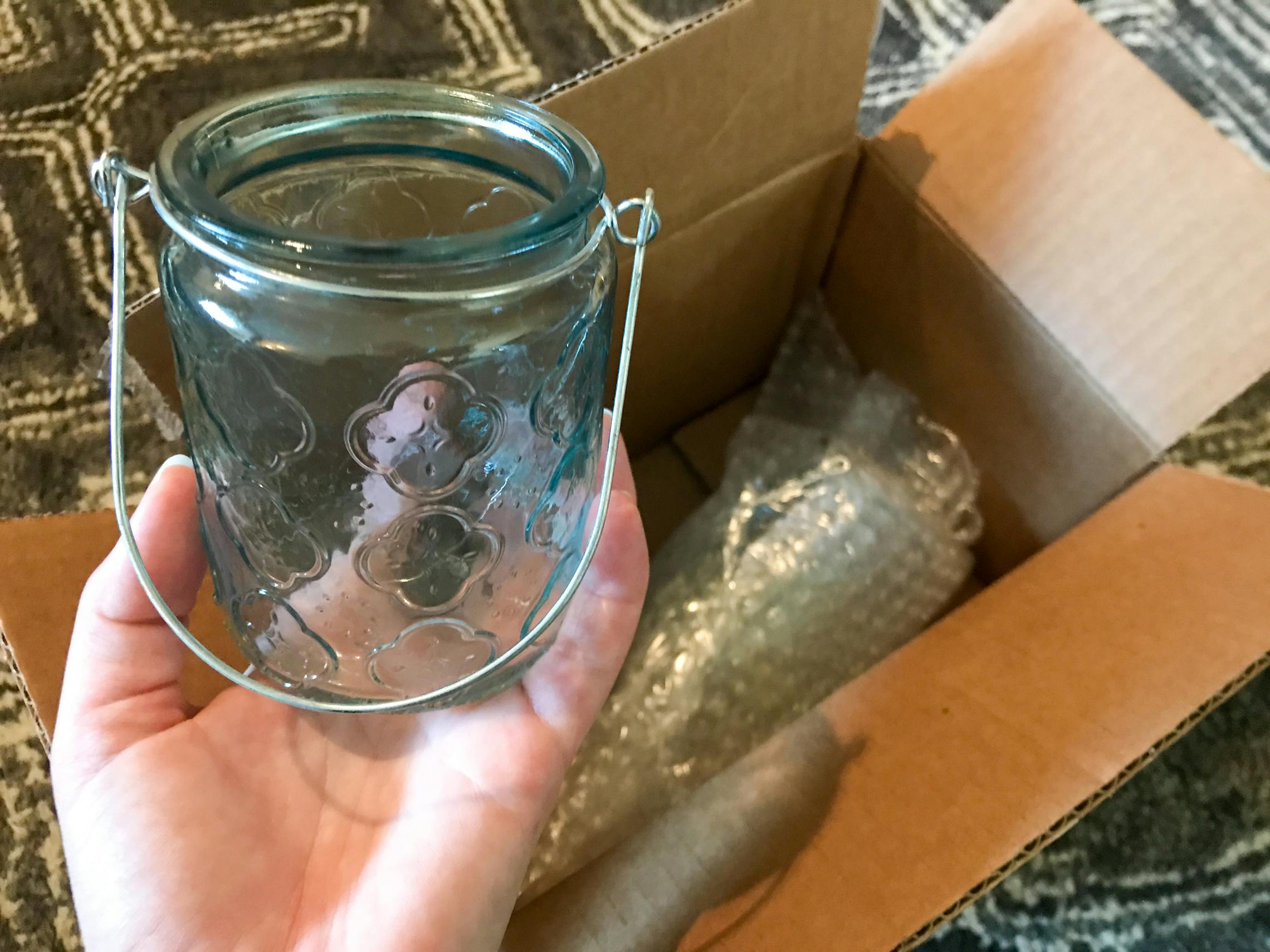 A candle holder from Hobby Lobby being pulled from delivery box