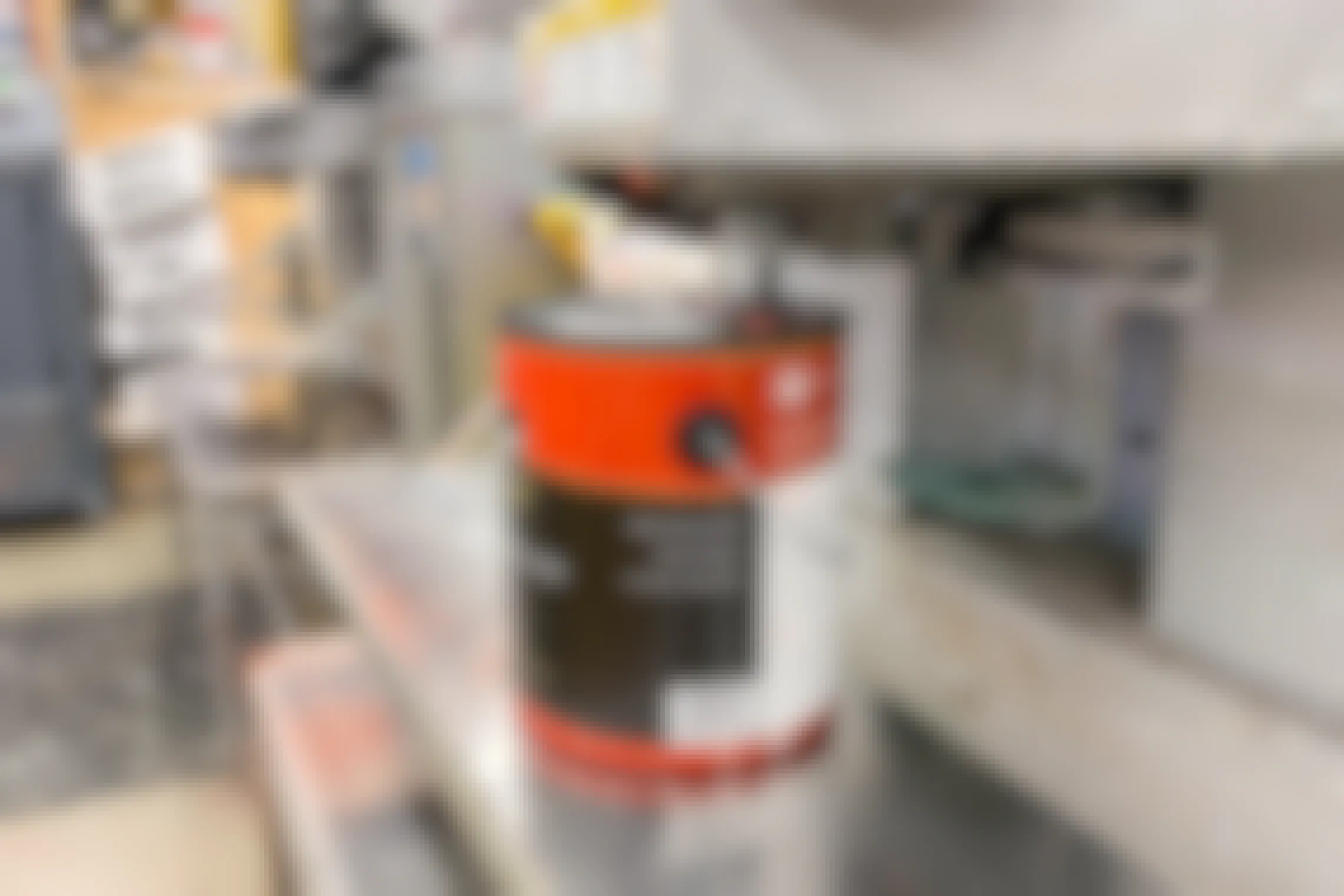 An open can of paint sitting below the machine used for tinting paint.