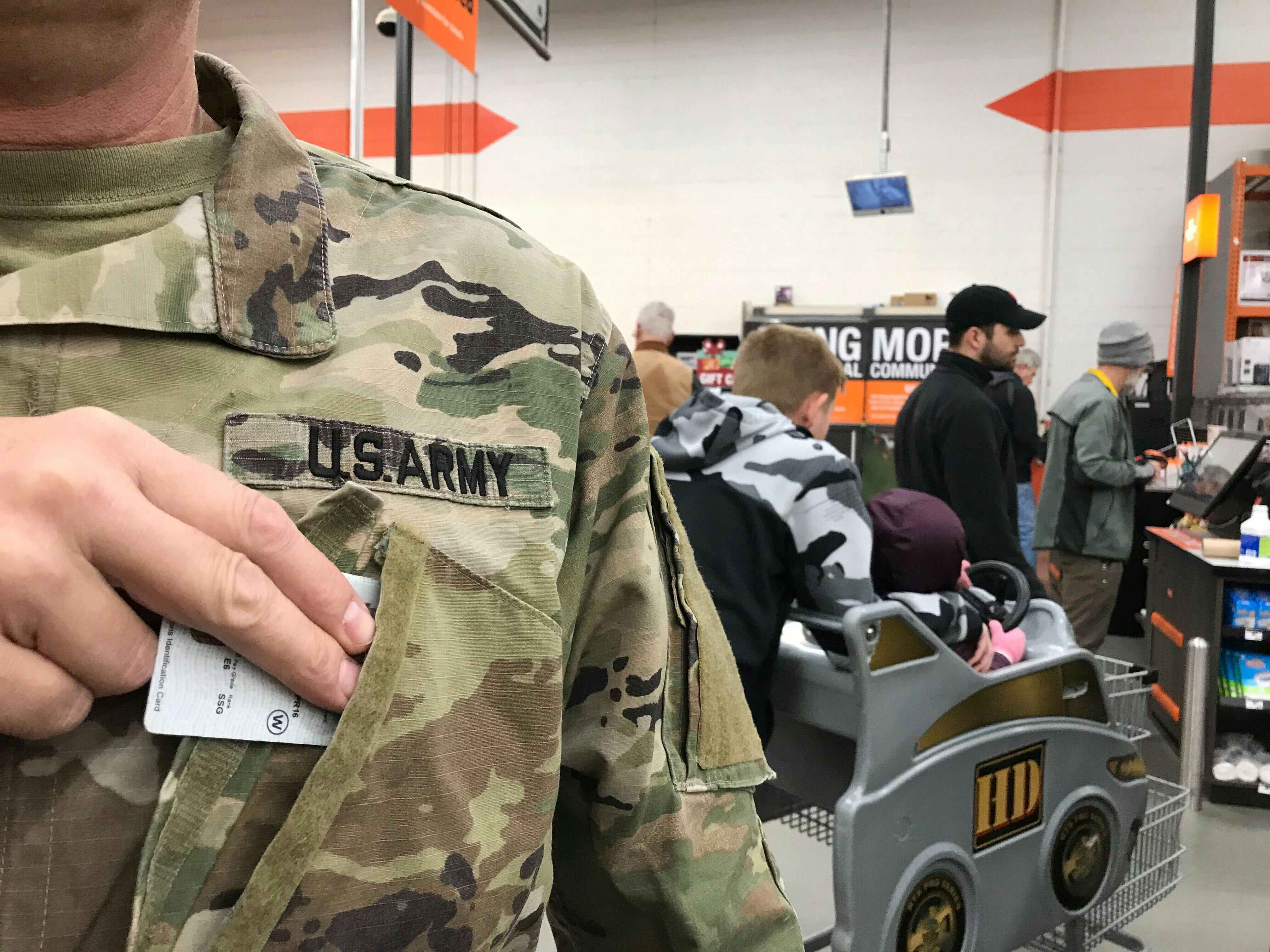 a military person in a home depot grabbing their military ID