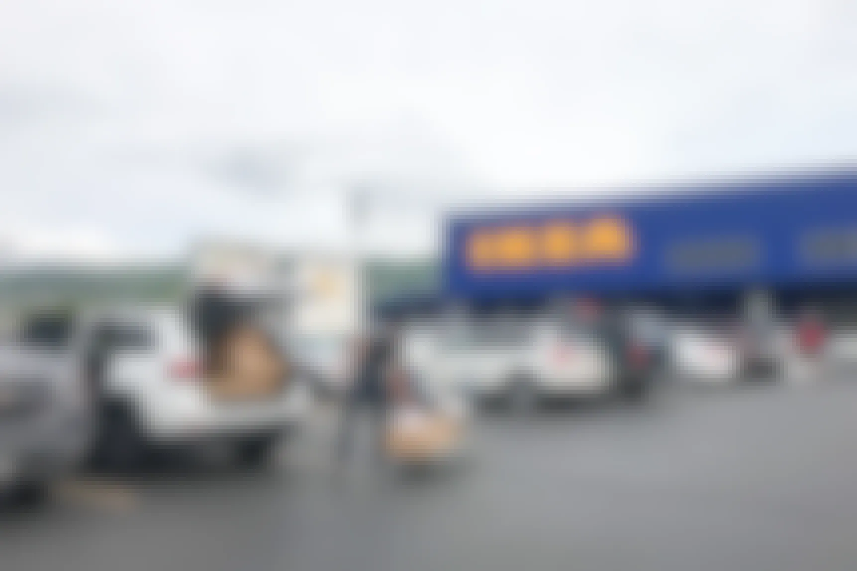 Man loading Ikea package into his vehicle outside Ikea.