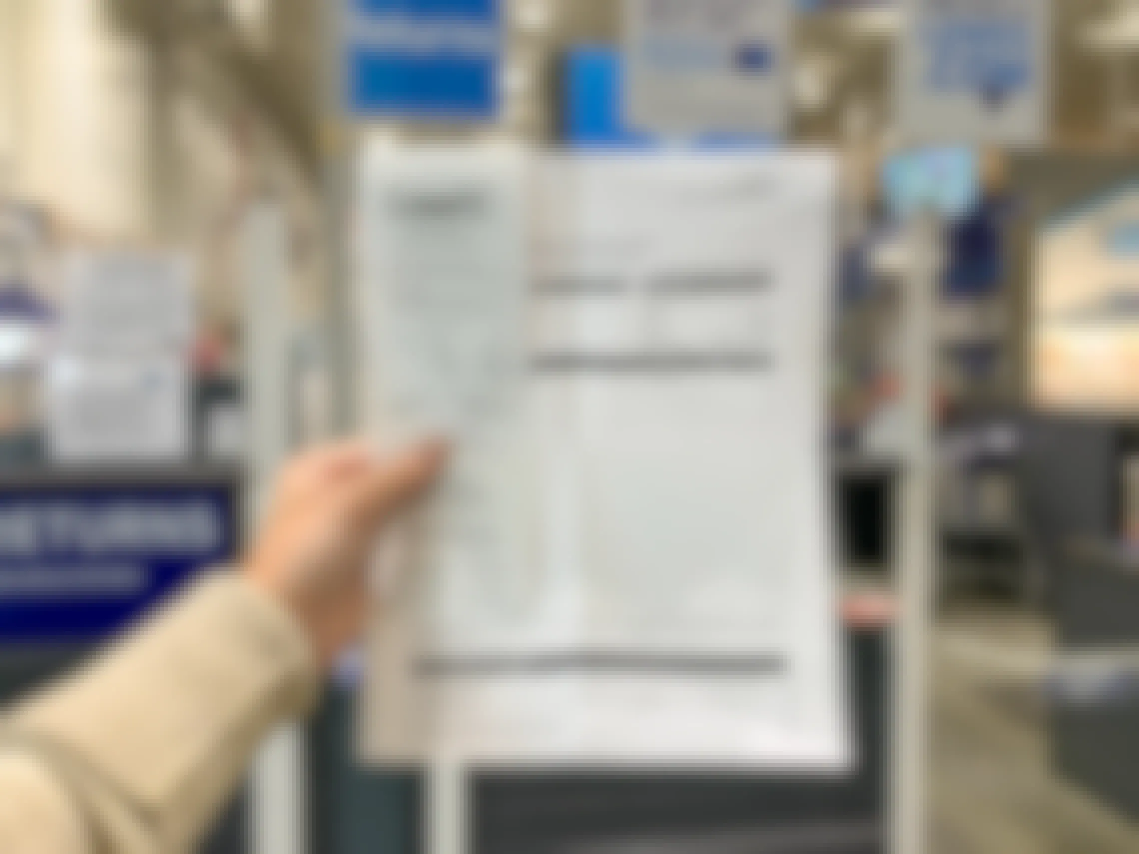 A person's hand holding up their Lowe's black friday return receipt at the Lowe's return counter.