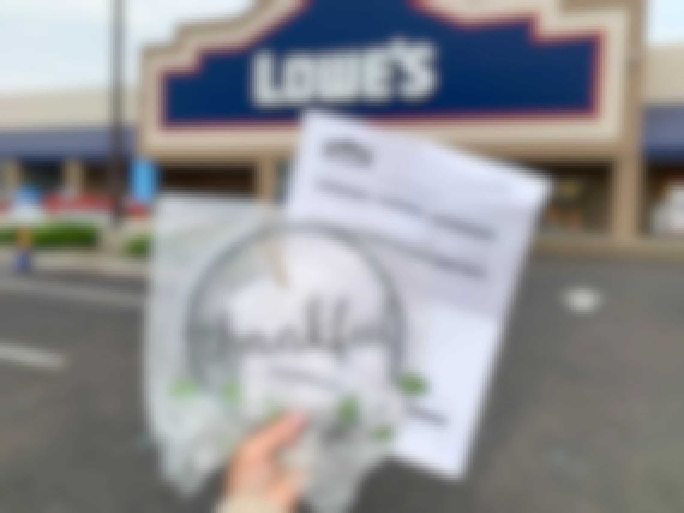 A Lowes return receipt and a thankful sign held in front of Lowes