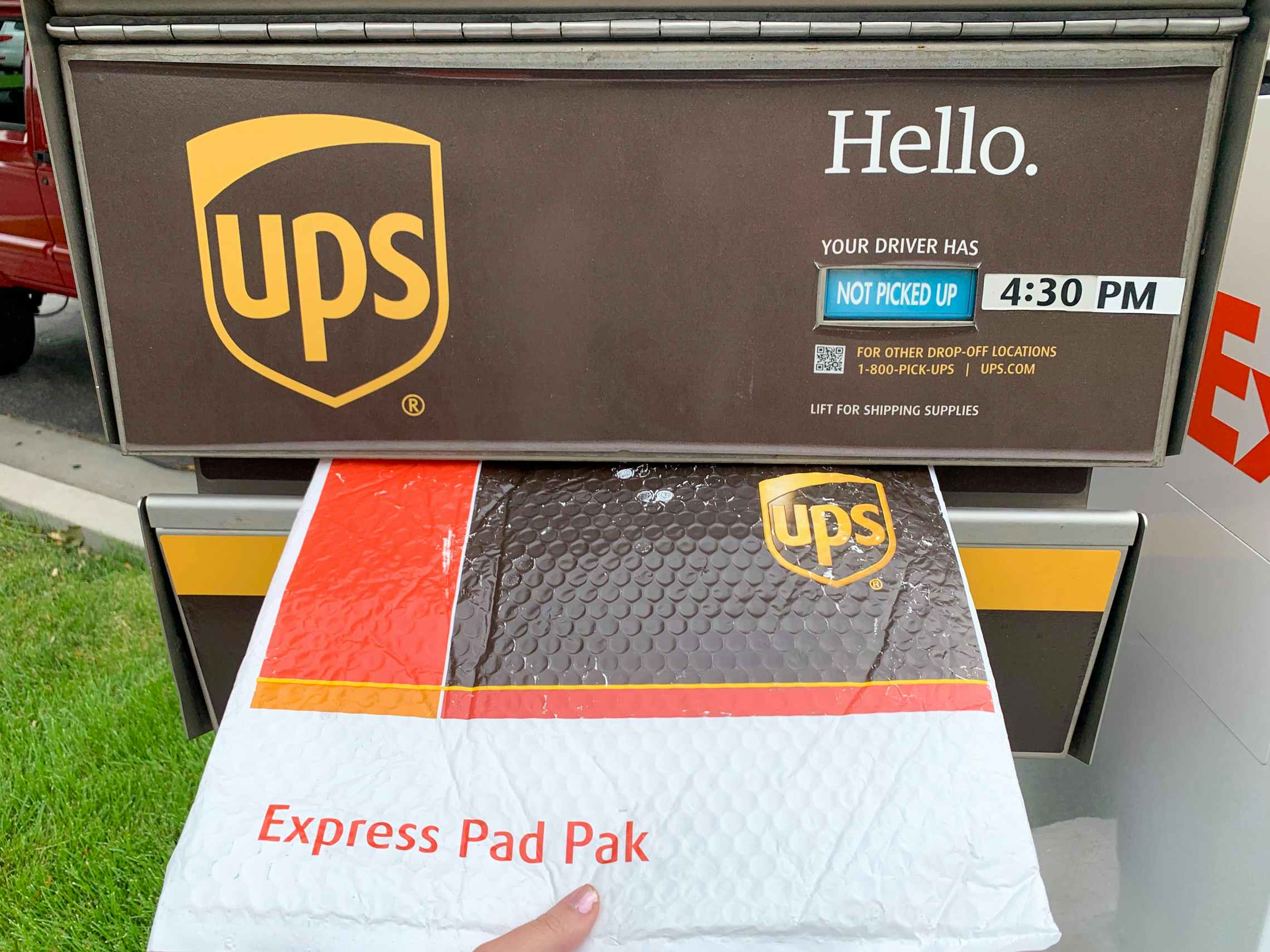 A UPS package being dropped in a UPS mail box.