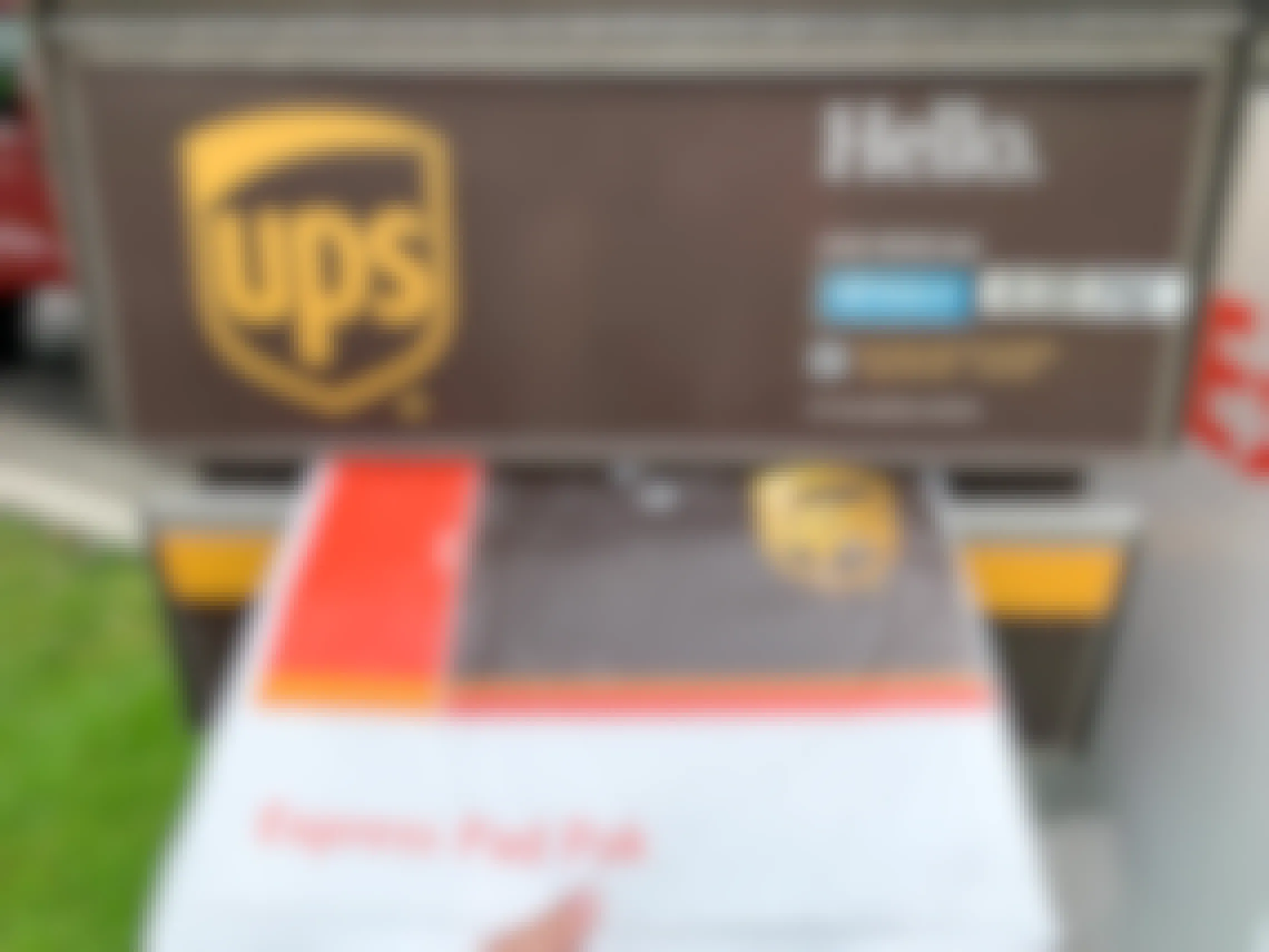 A UPS package being dropped in a UPS mail box.