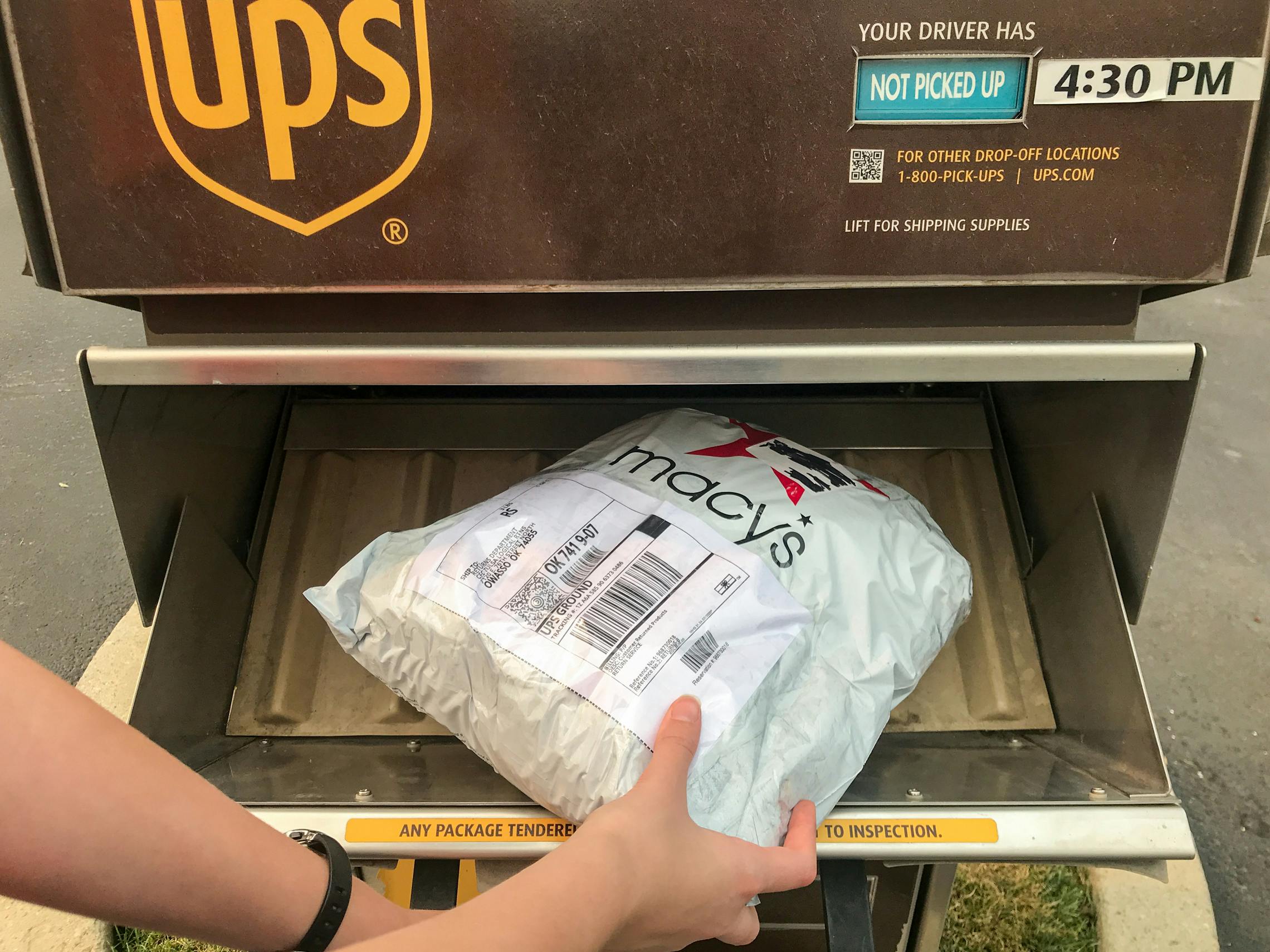 someone putting macys package in ups mailbox