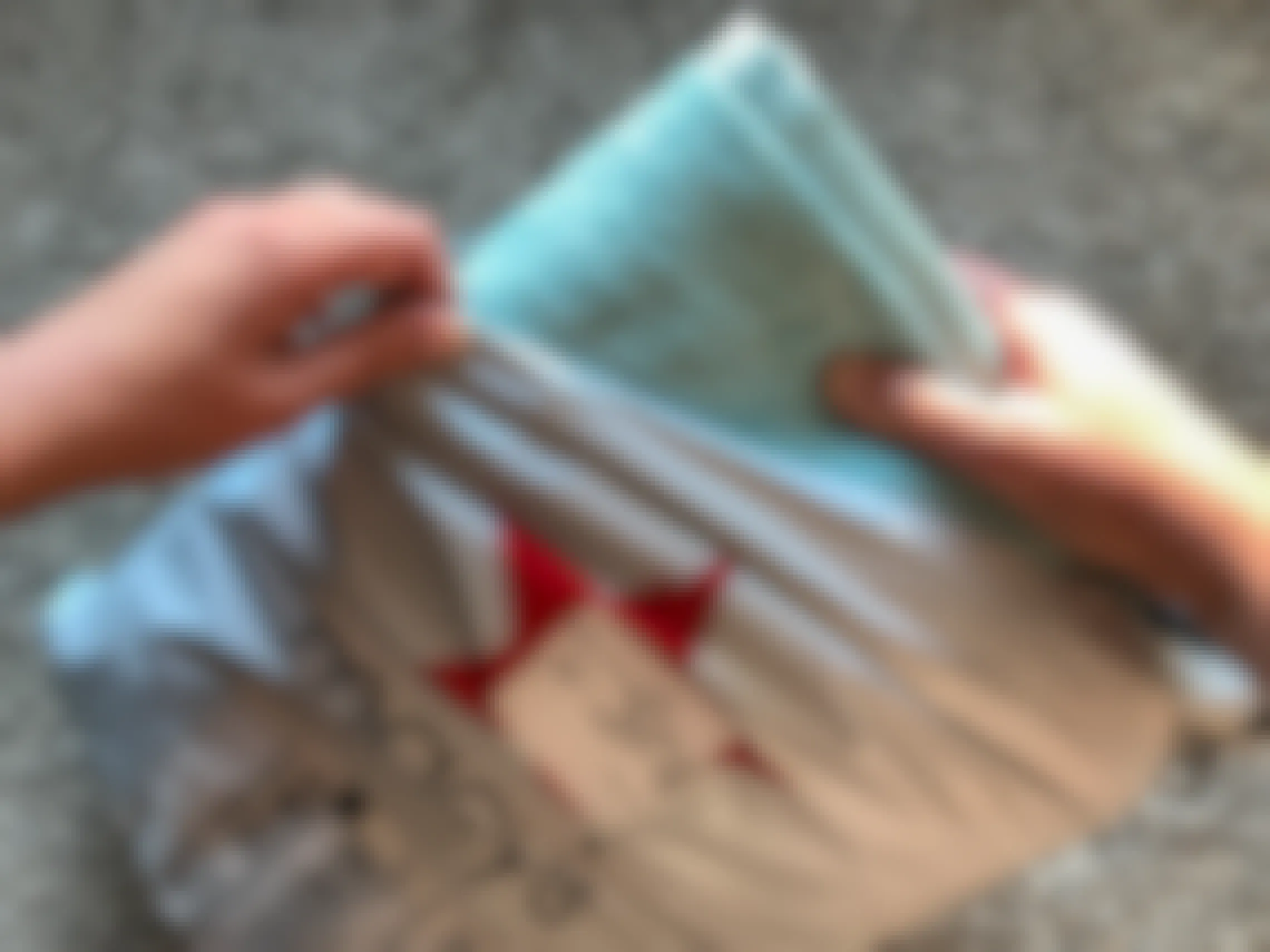 A woman pulling out a towel from a macys online order bag.