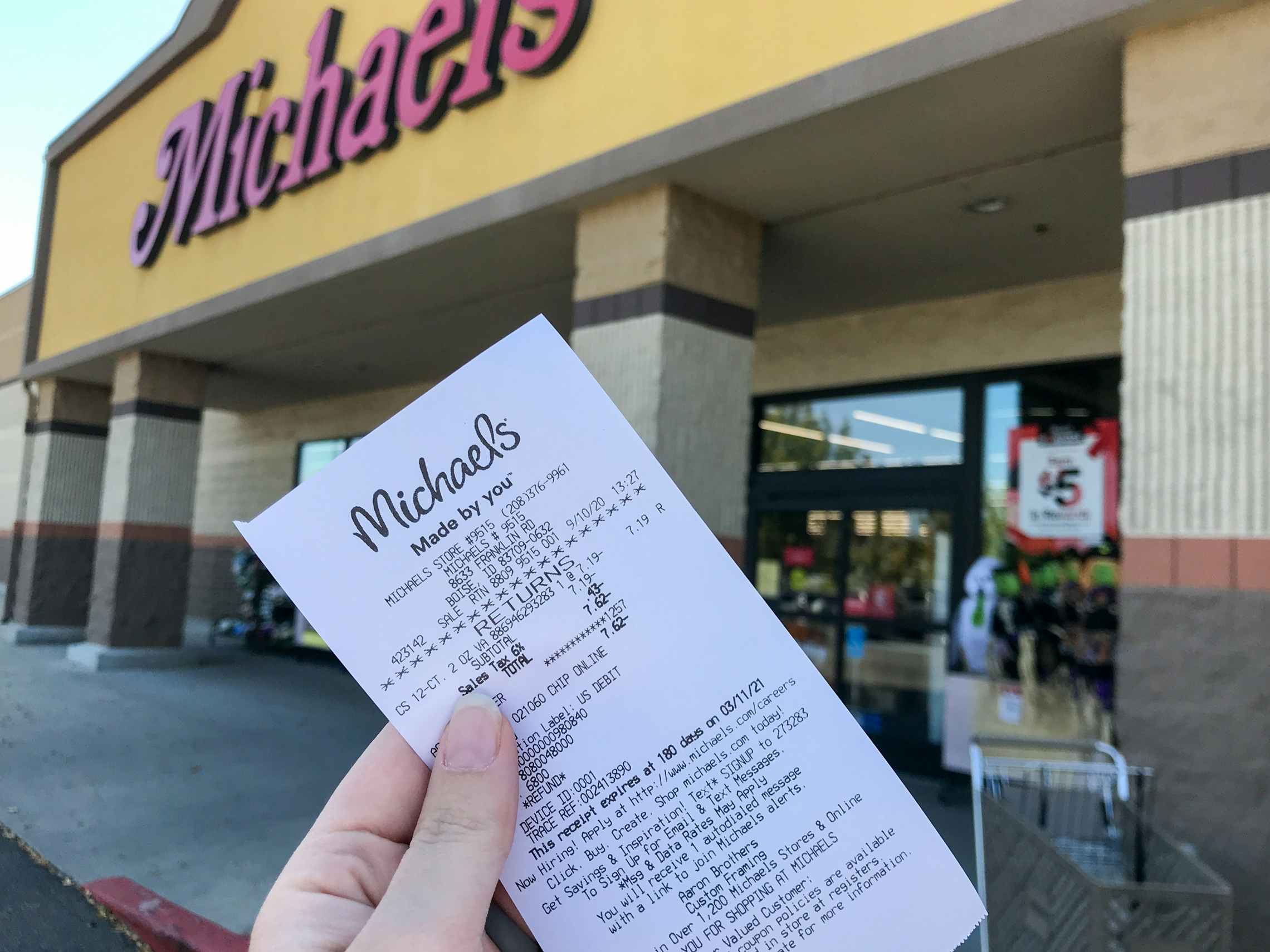 someone holding receipt in front of michaels