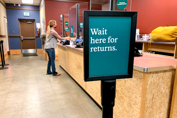 Return counter line starts here sign inside REI