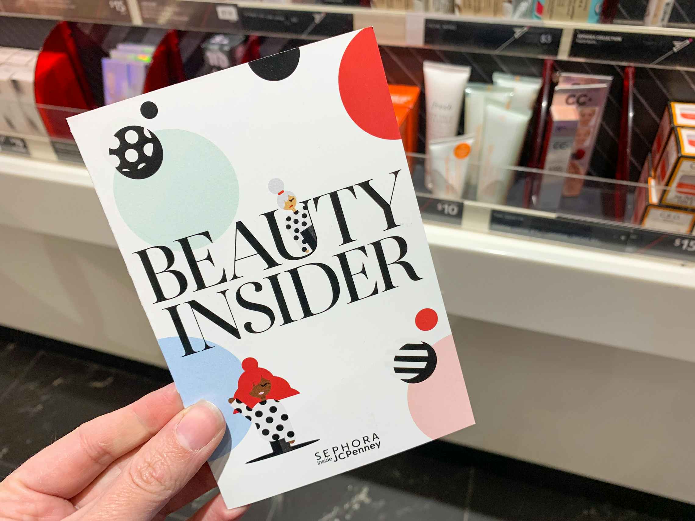 A Sephora insider brochure held near checkout
