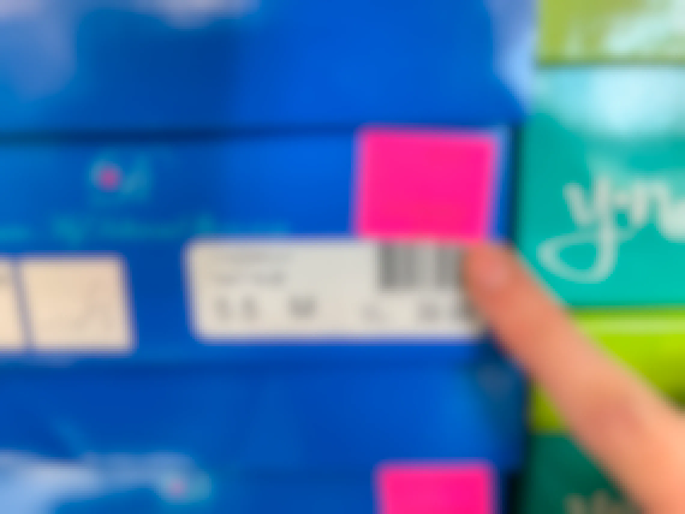 A person pointing out the price pink price tag on a box of shoes.