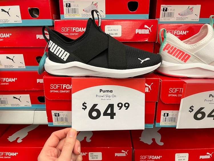 A pair of Puma running shoes on a shelf with shoe boxes and a price tag reading, "$64.99".