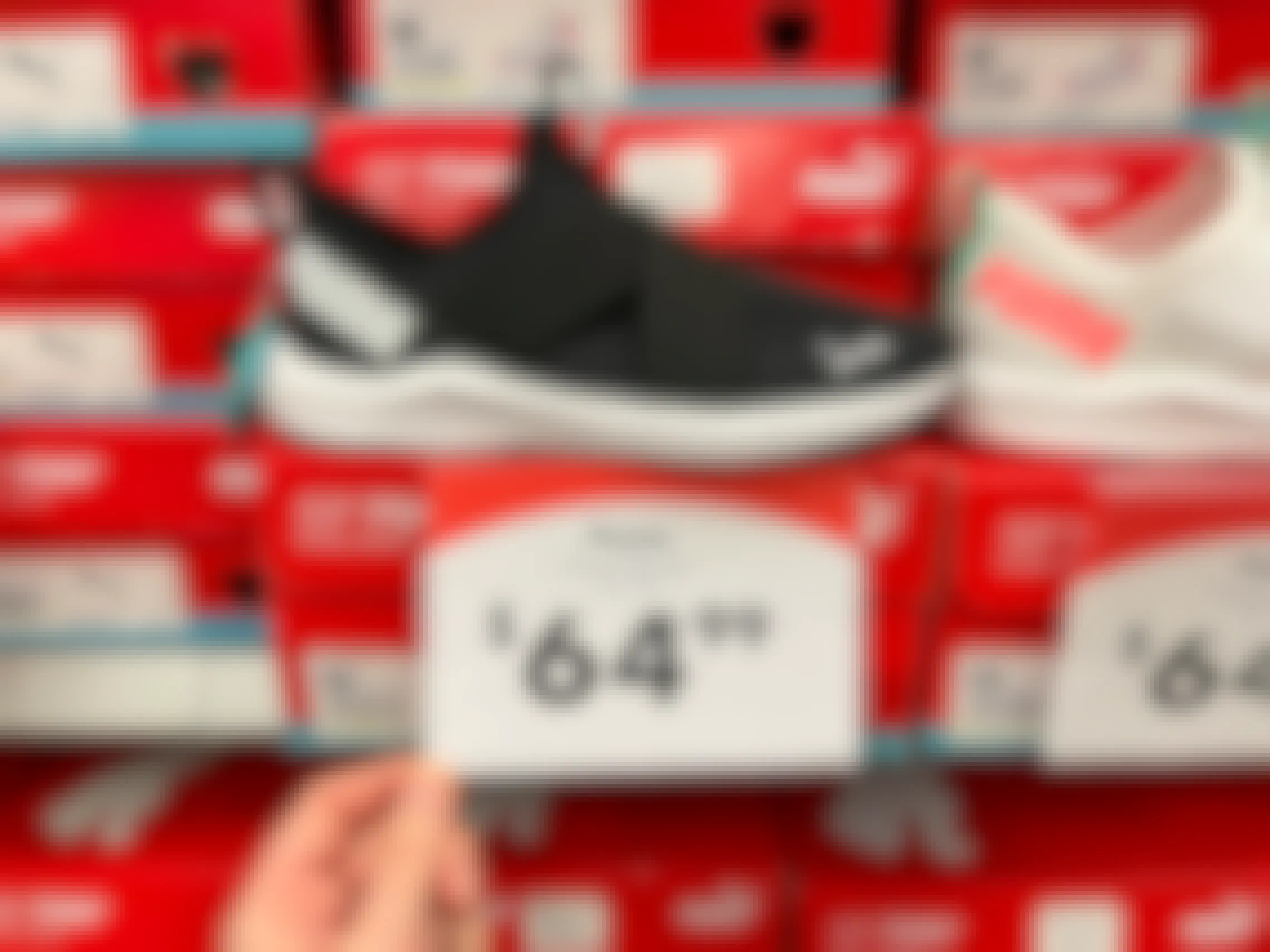 A pair of Puma running shoes on a shelf with shoe boxes and a price tag reading, "$64.99".