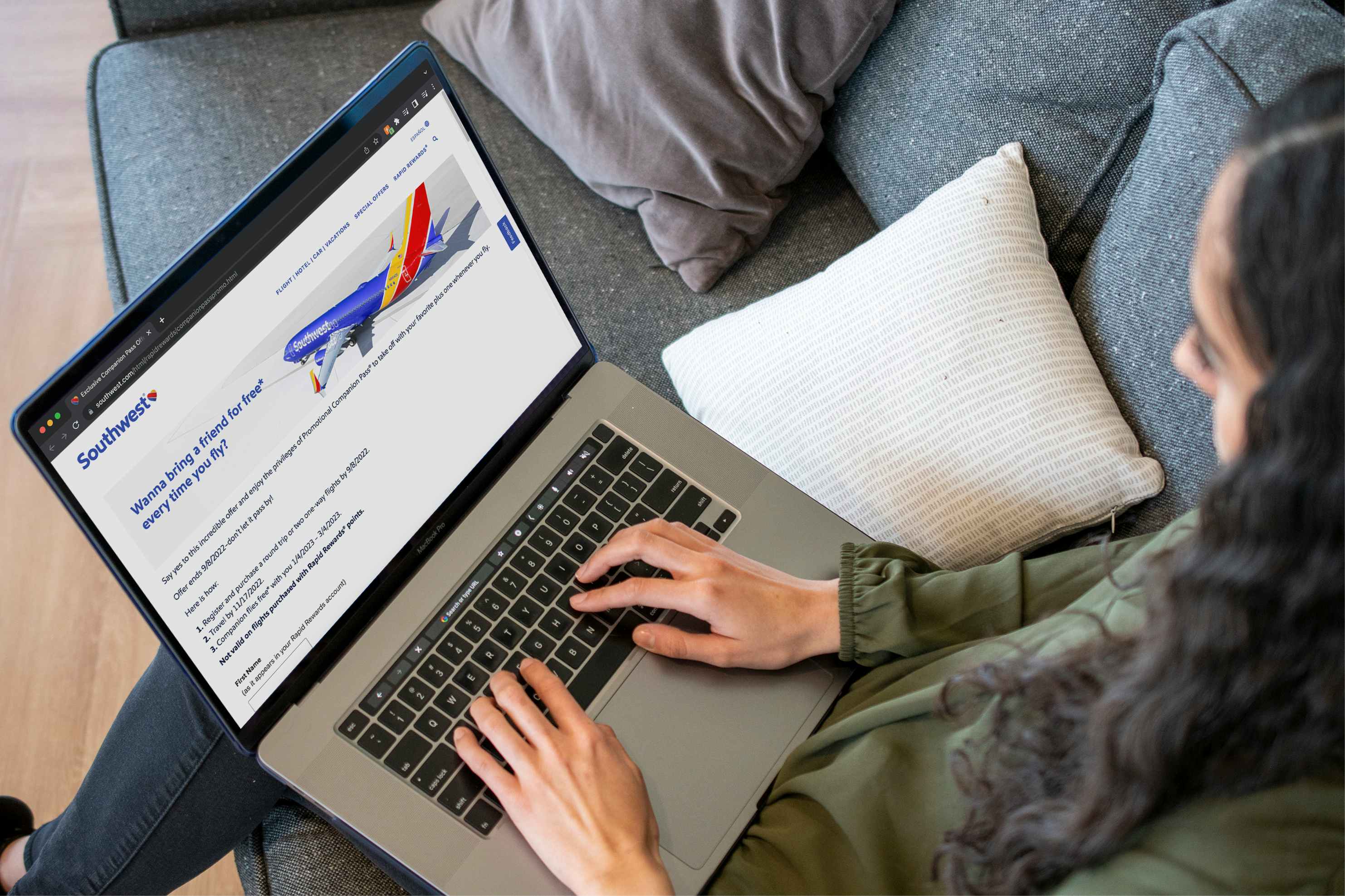 A person using a laptop displaying the Southwest Airline website's page for Free Companion Pass.