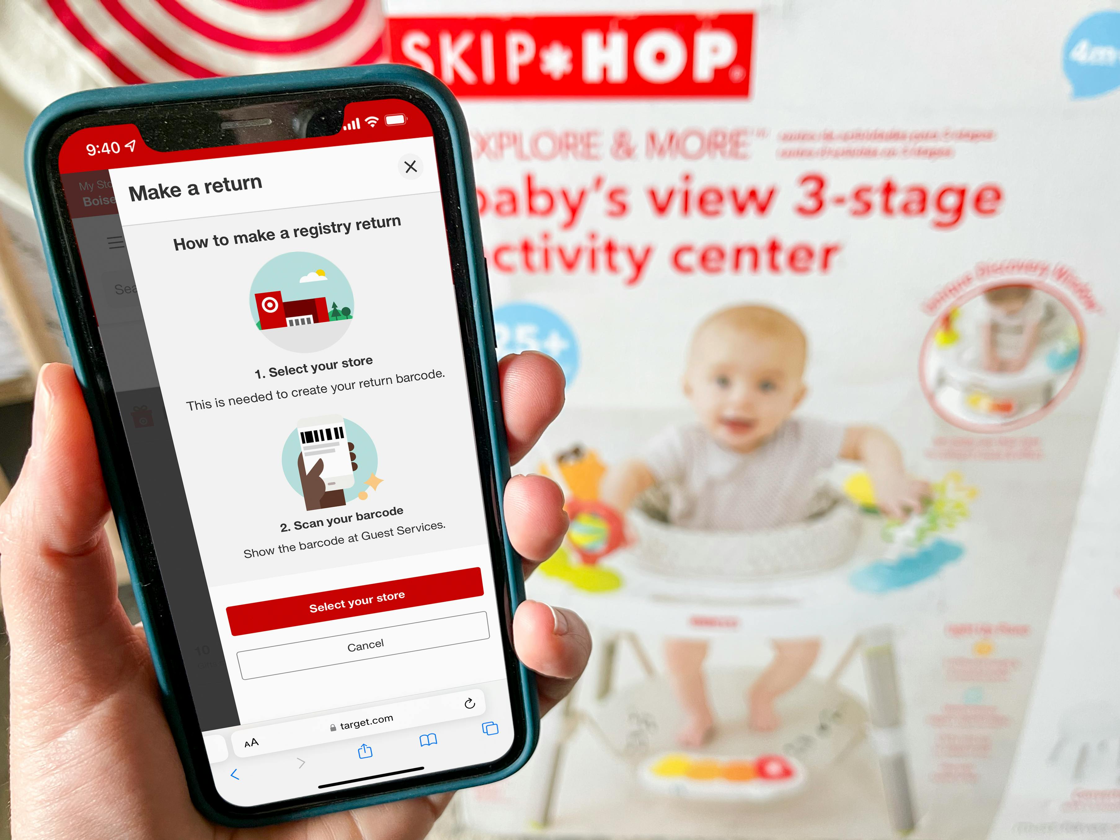 The baby registry return instructions on the target app displayed on a cell phone, held net to a Skip Hop baby activity center box.