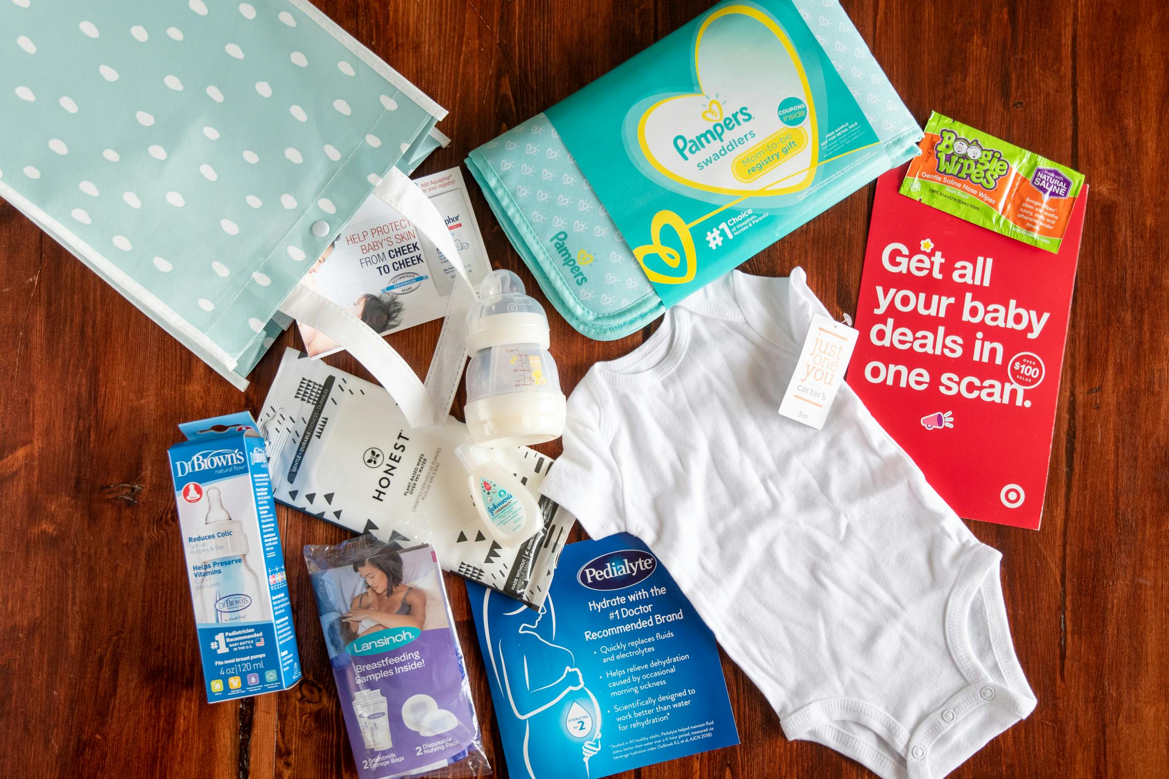 Contents of a free Target registry baby bag laid out on a wood floor.