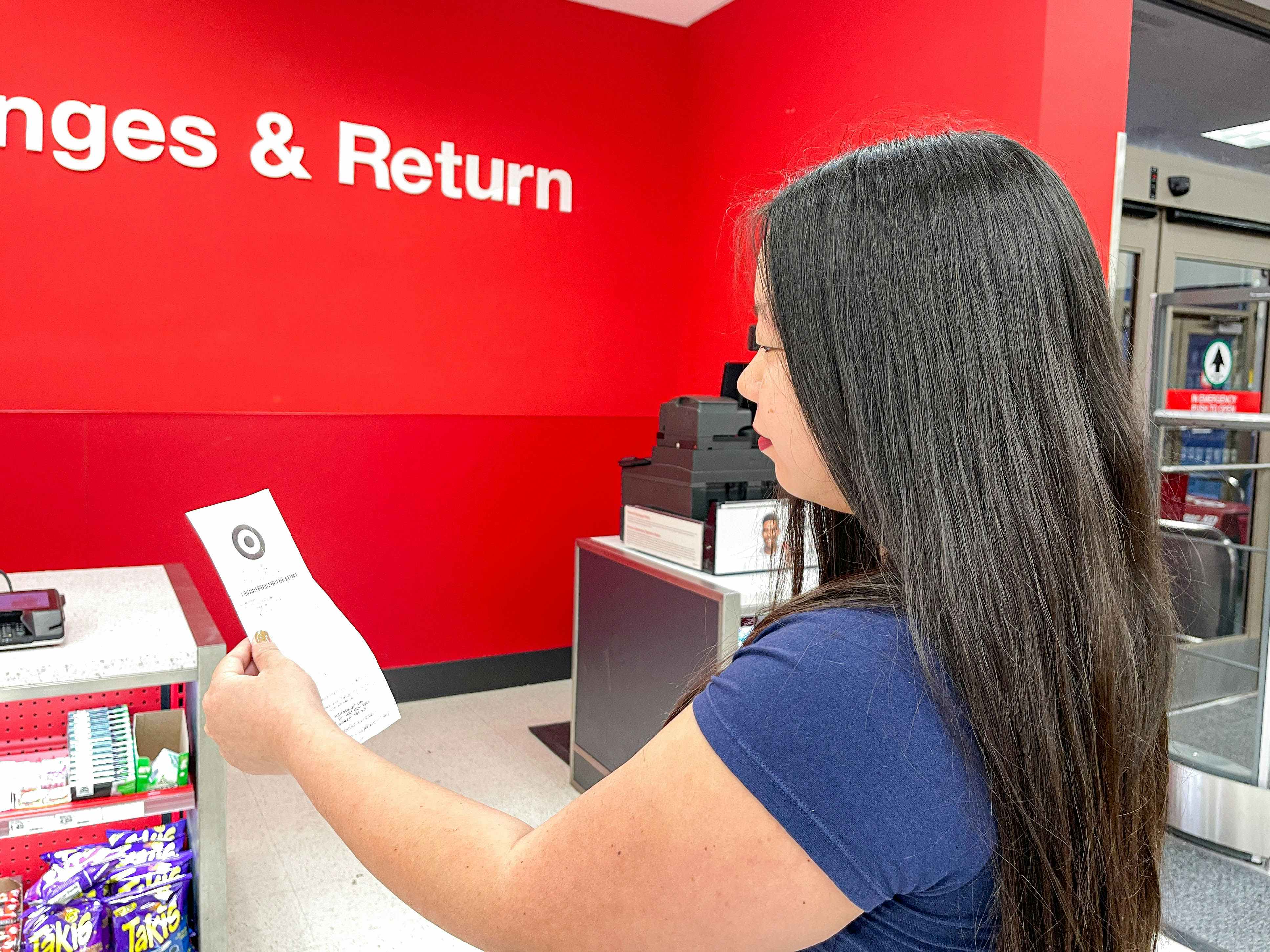 a woman holding a recepit standing in line at the target returns